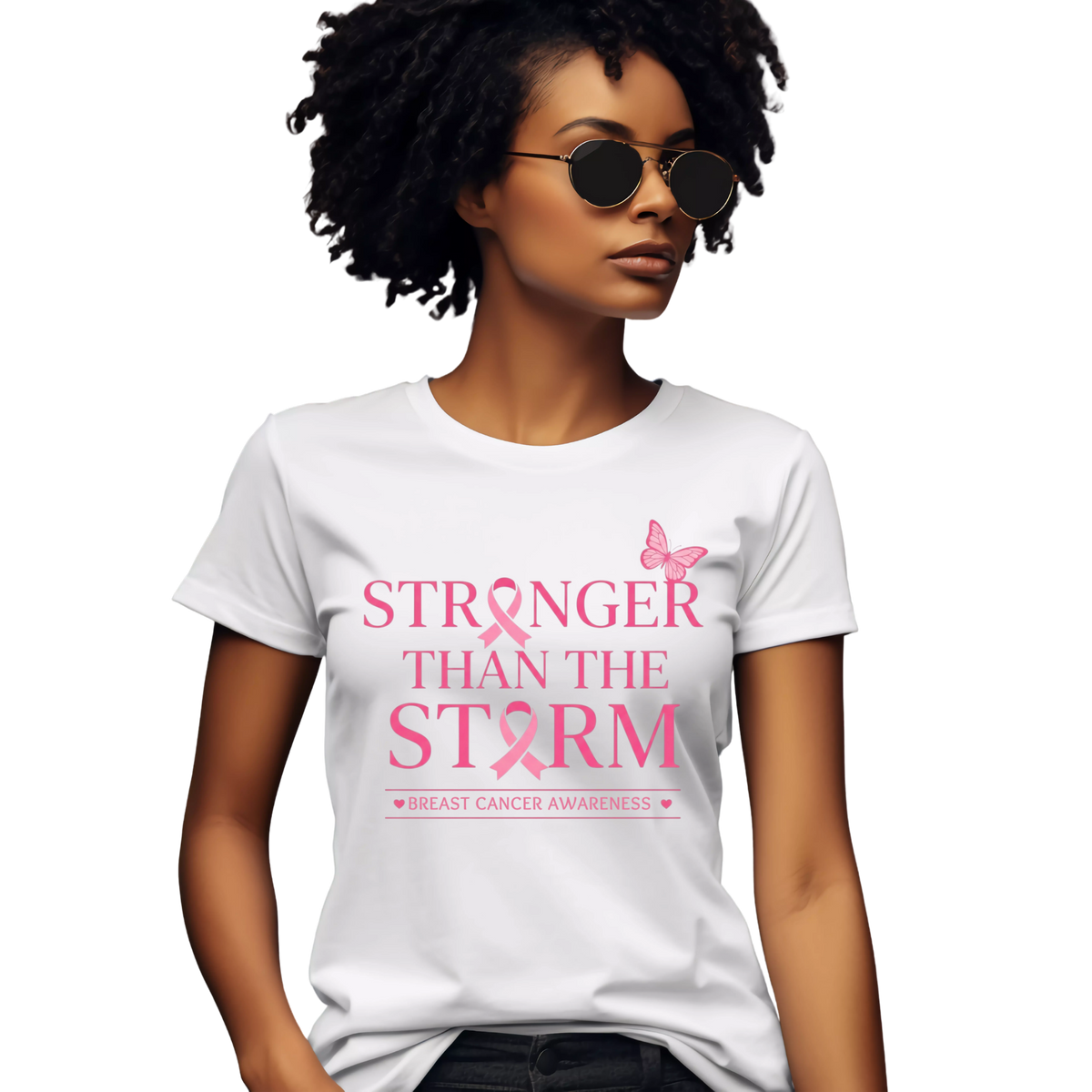 A woman wearing a white short-sleeve graphic T-shirt with pink text reading 'STRONGER THAN THE STORM' and 'BREAST CANCER AWARENESS' with a pink ribbon and butterfly, shown against a plain white background.