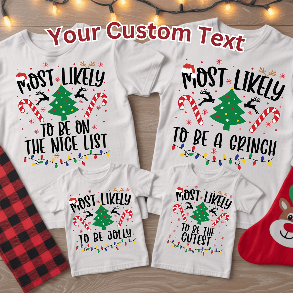 Three white Christmas family T-shirts laid out on a wood surface with holiday props. The shirts feature different printed phrases: 'Most Likely To Be On The Nice List,' 'Most Likely To Be A Grinch,' and 'Most Likely To Be The Cutest,' each with a green Christmas tree, candy cane, sleigh, reindeer, and colorful string lights.