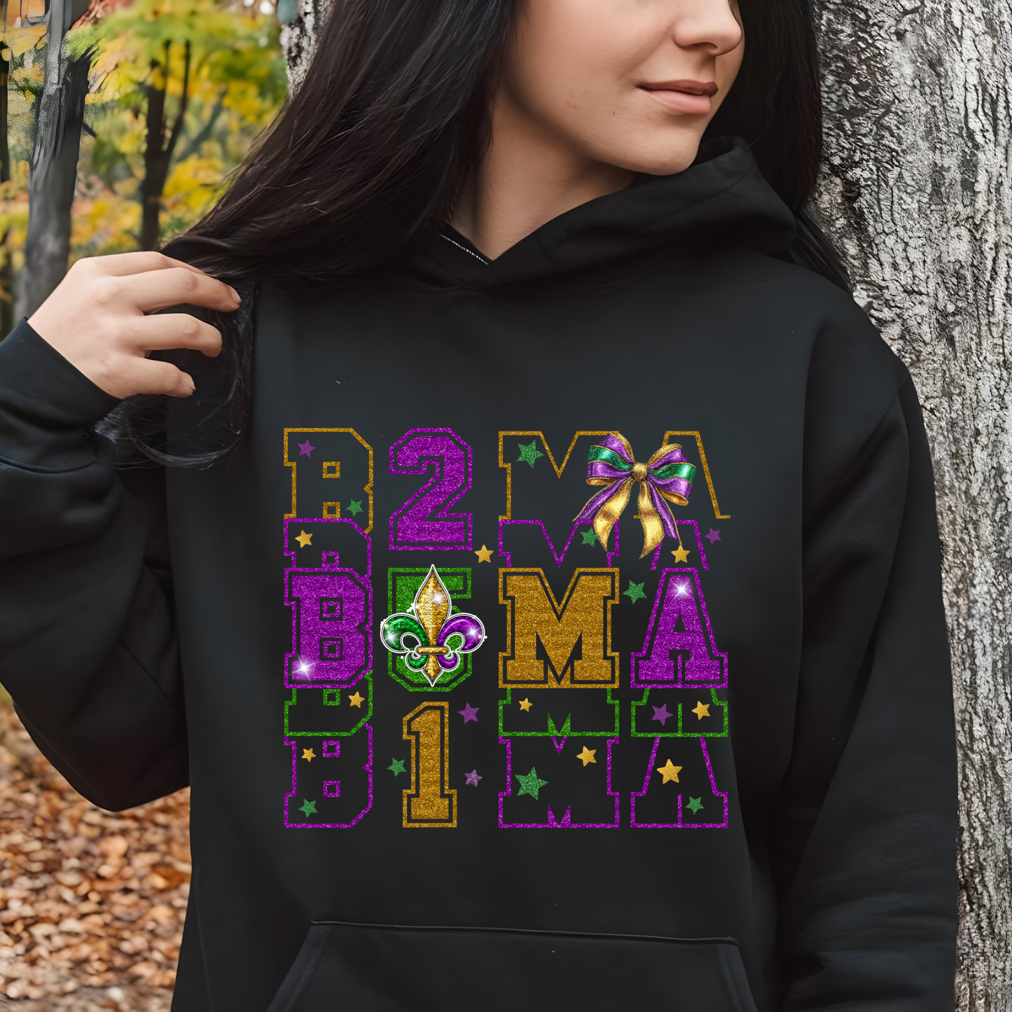 Person wearing a black hoodie with colorful text and designs, standing outdoors.