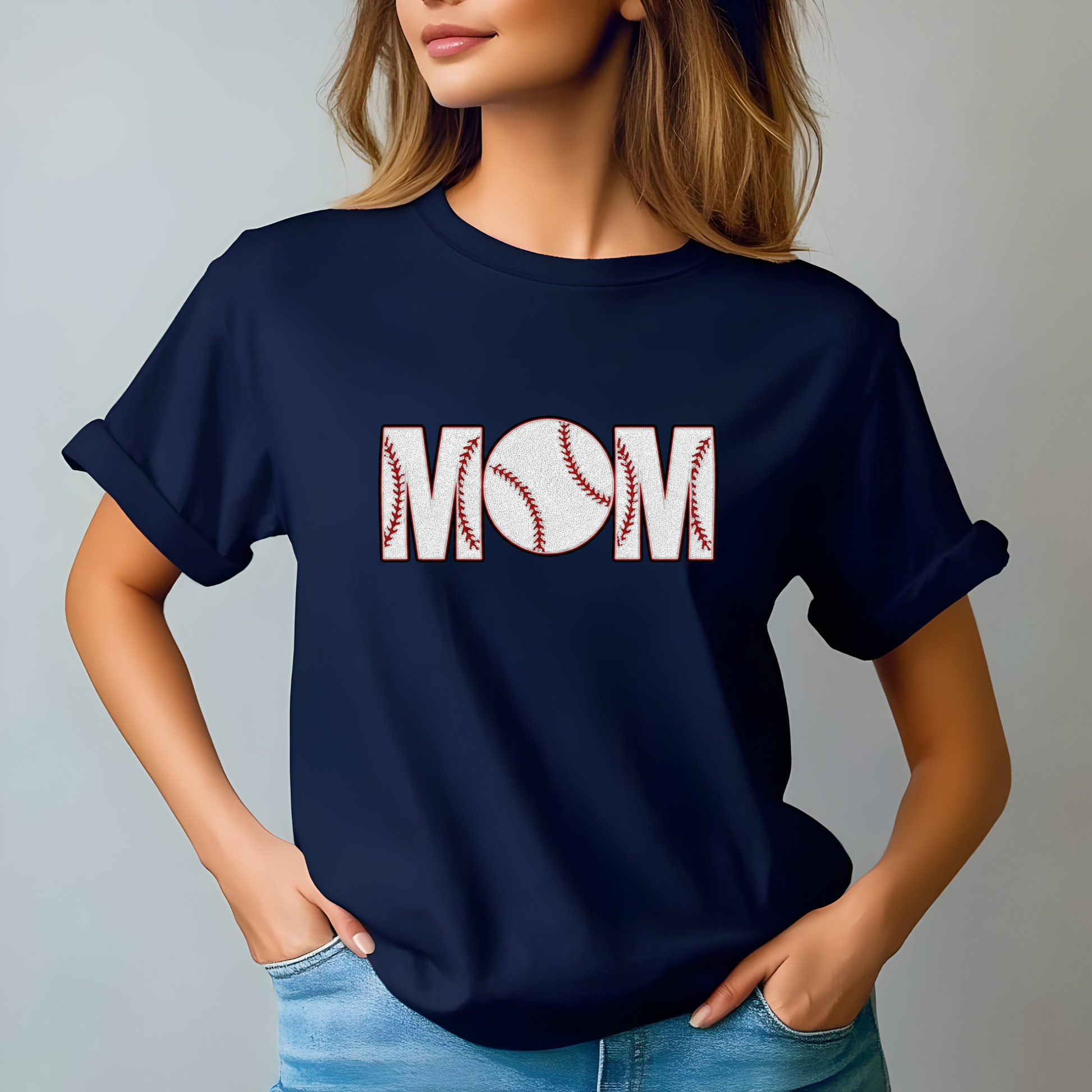 Navy blue t-shirt with 'MOM' design worn by a person on a plain background