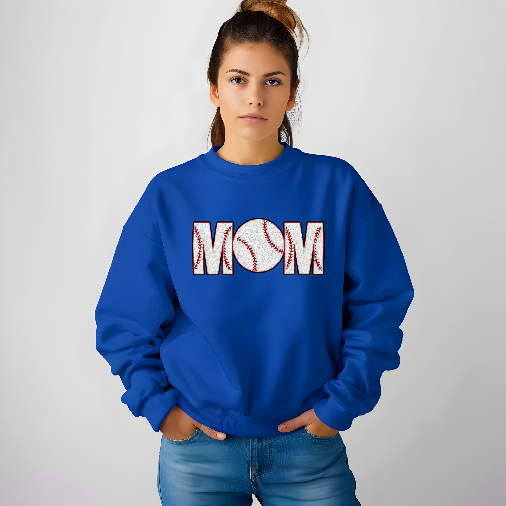 Person wearing a blue sweatshirt with 'MOM' and a baseball design on a plain background