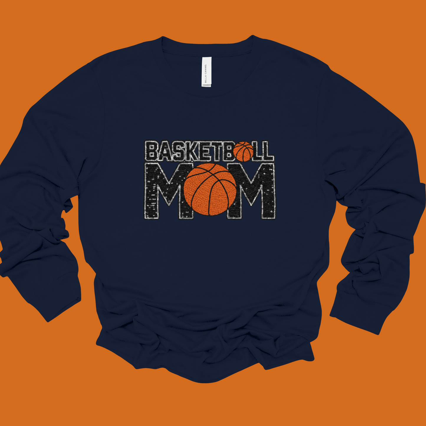 Navy sweatshirt with 'Basketball Mom' text and basketball graphics on an orange background