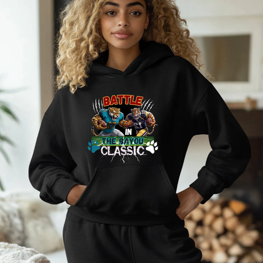 Person wearing a black hoodie with a graphic design in a home setting  Bayou Classic Hoodie: Battle in the Bayou Classic Game Day Unisex Hoodie