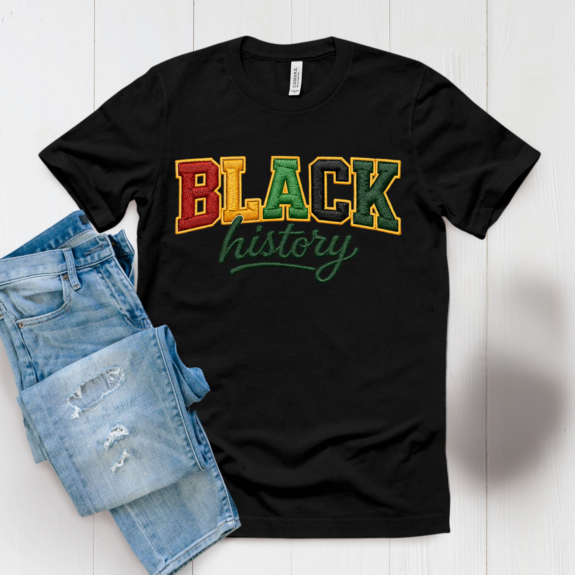 Black t-shirt with 'BLACK history' text in multicolor on a white surface with denim shorts.