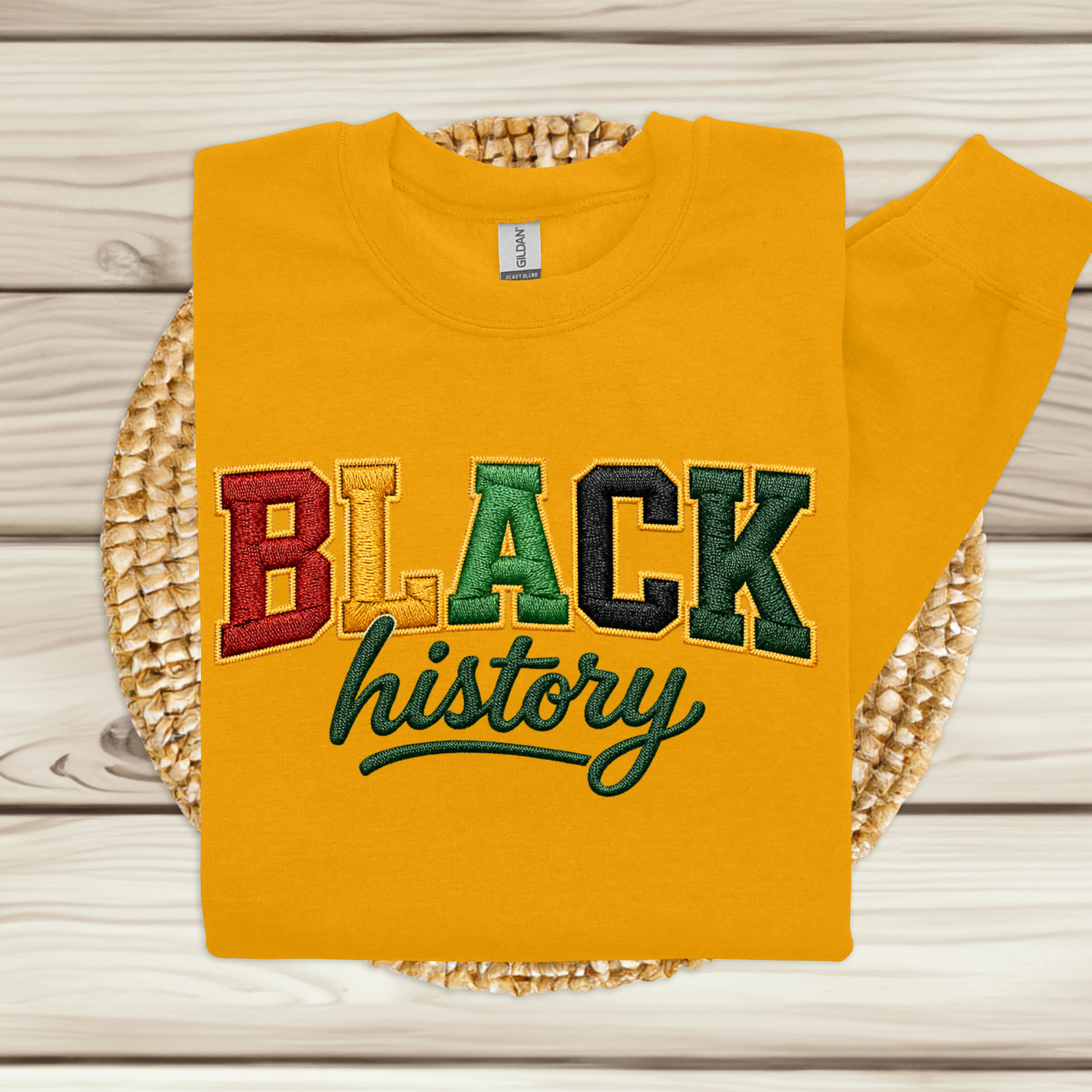 Yellow sweatshirt with 'BLACK history' text on a woven mat