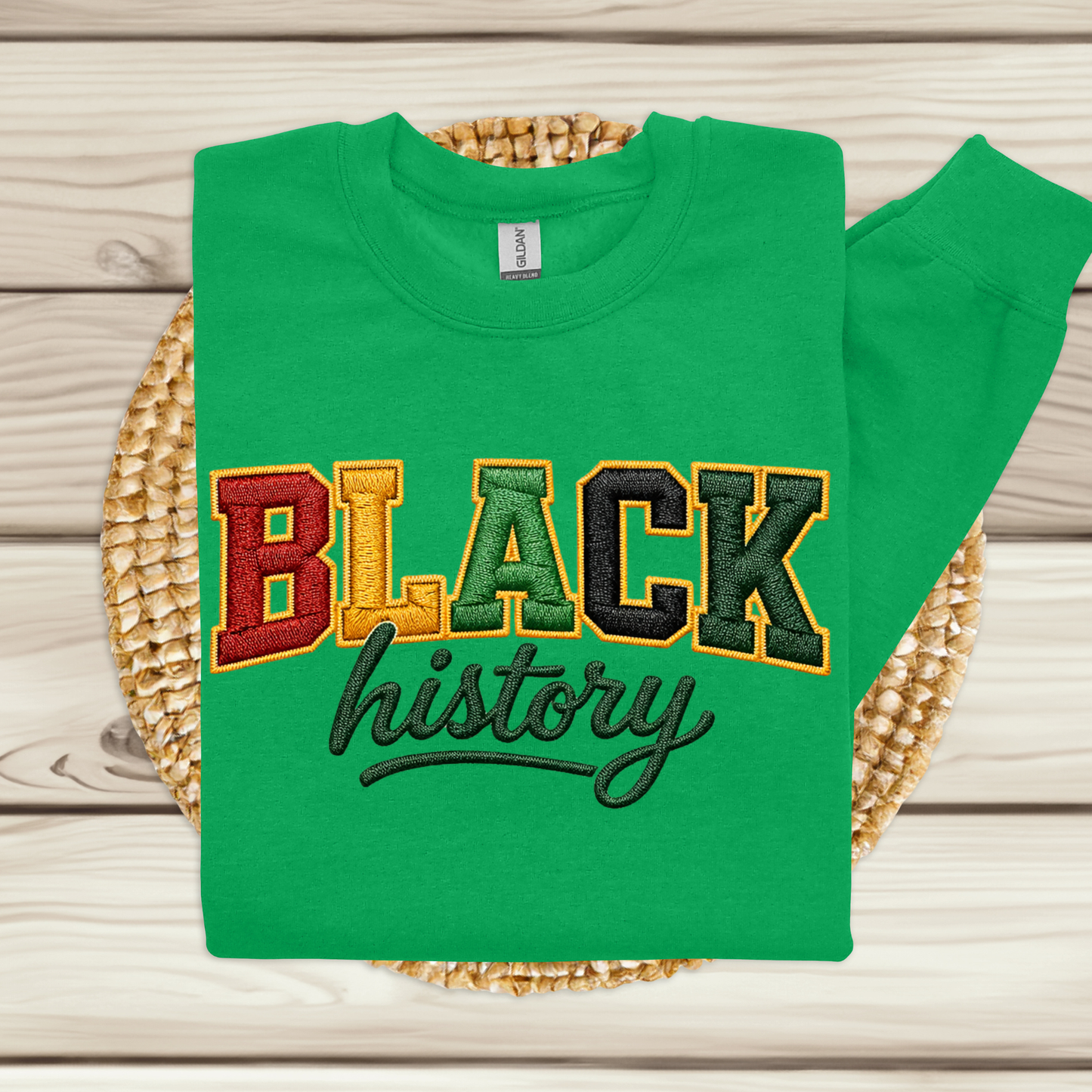 Green sweatshirt with 'BLACK history' text on a woven mat