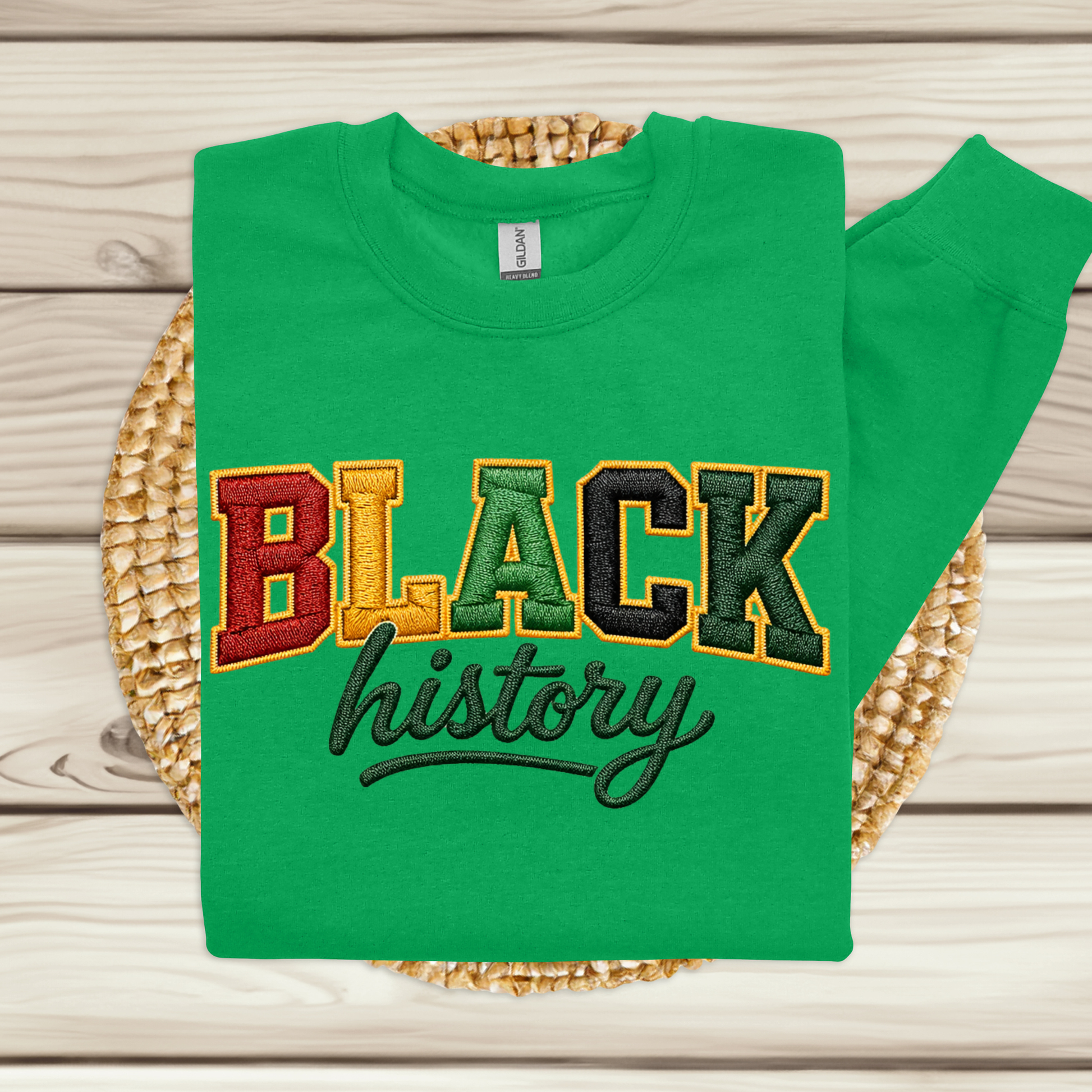 Green sweatshirt with 'BLACK history' text on a woven mat
