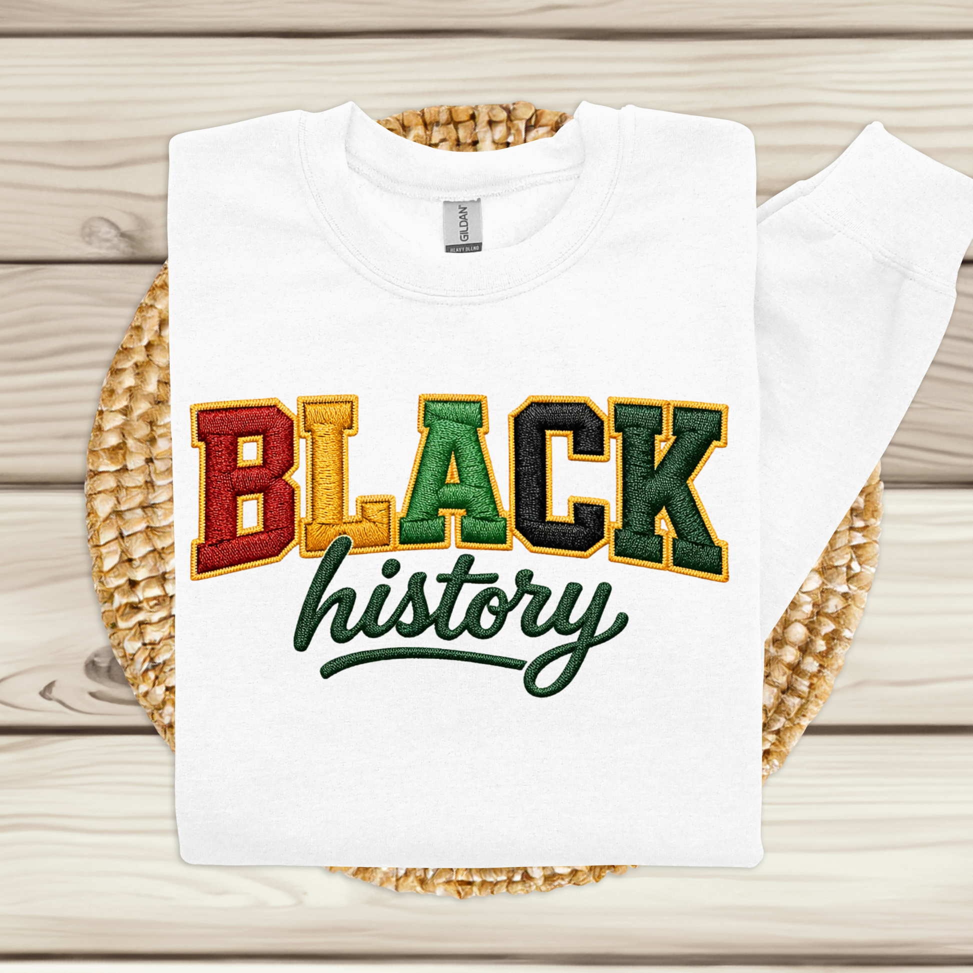 White t-shirt with 'BLACK history' text in multicolor on a woven mat.