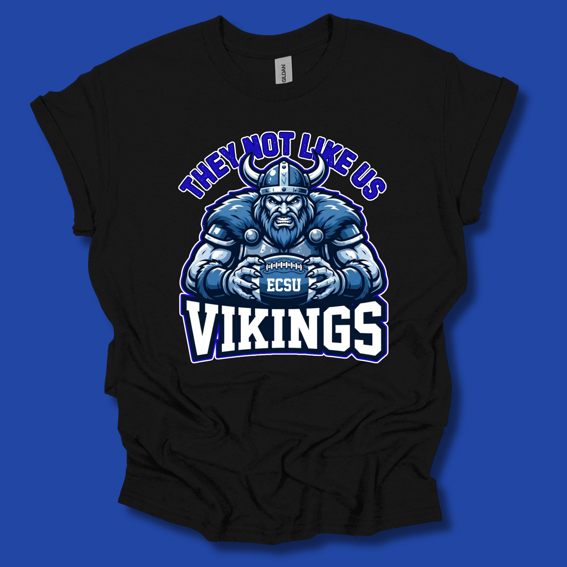 A black short-sleeve t-shirt with a graphic of a blue and white Viking holding an EC SU football, with the text 'THEY NOT LIKE US' above and 'VIKINGS' below, displayed against a solid blue background.
