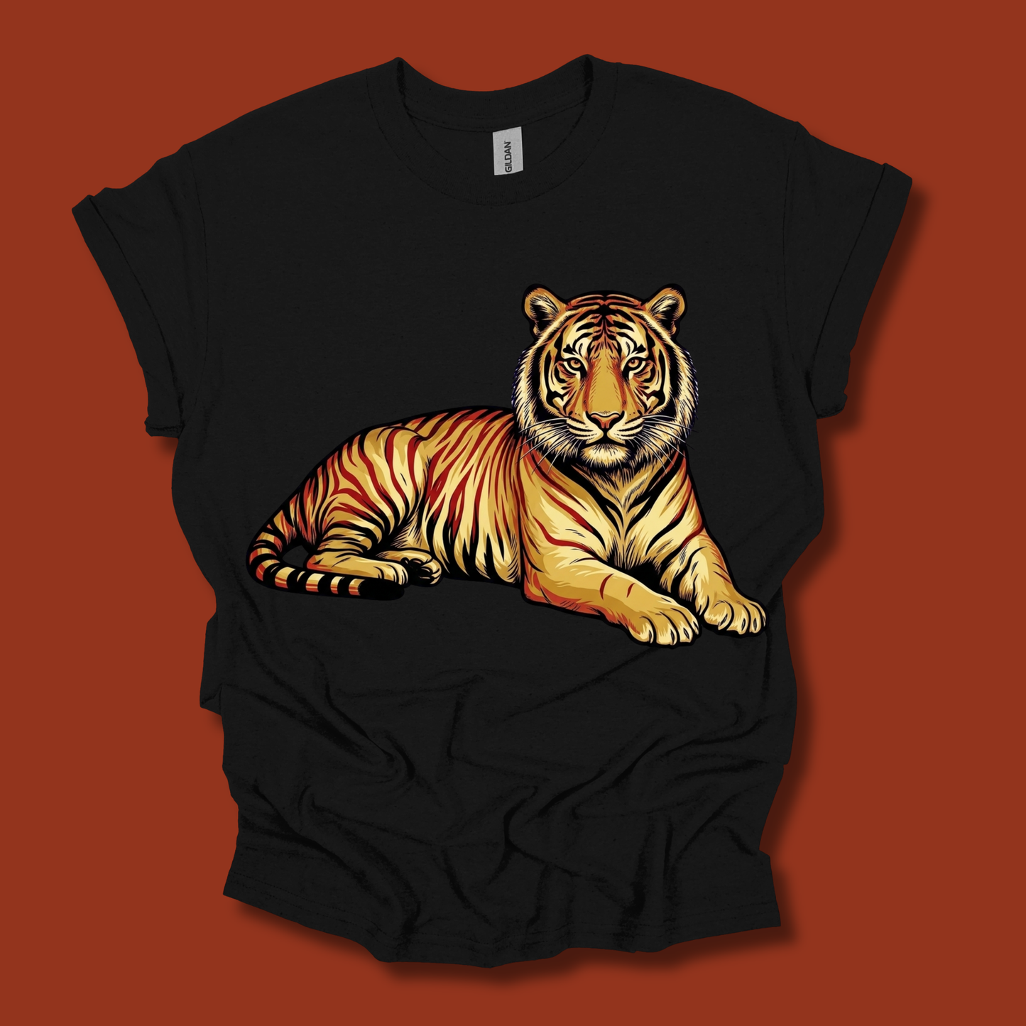 A black short-sleeve t-shirt with a detailed graphic of a resting tiger in orange, yellow, and black stripes, displayed against a solid dark red background.