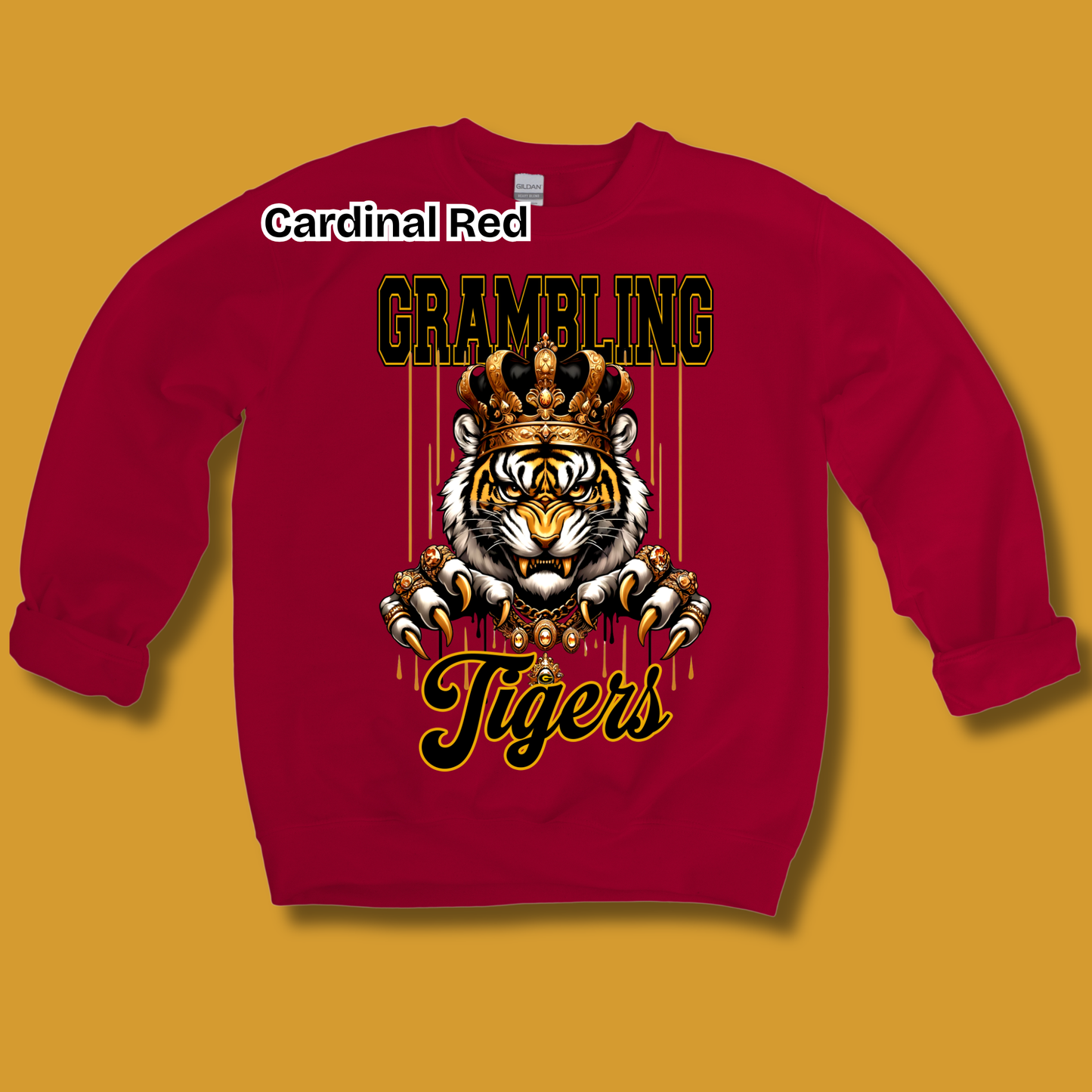 A red crewneck sweatshirt with a graphic of a tiger wearing a crown and the text 'GRAMBLING Tigers' in black and gold. The text 'Cardinal Red' is written in a white oval above the collar.