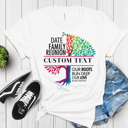 White t-shirt with colorful family reunion design on a wooden surface with shoes and shorts.