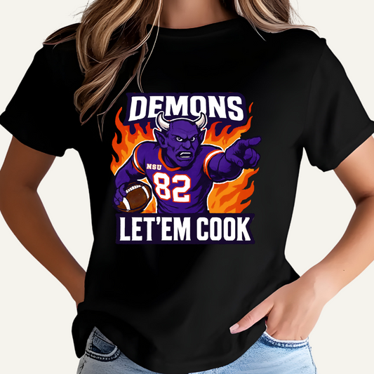 Black t-shirt with a graphic design of a demon holding a football, text 'DEMONS', '82', 'LET'EM COOK', and flames. Northwestern Demons Game Day T-Shirt - Demons  "Let'em Cook"  Football Tee