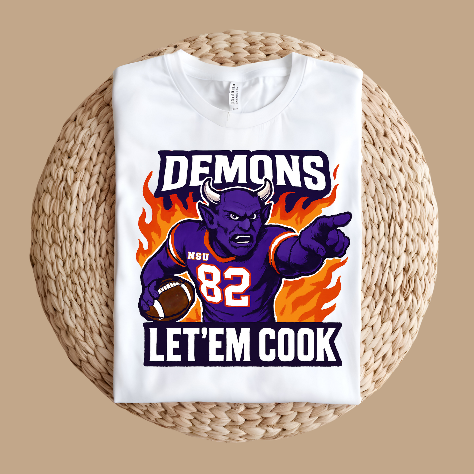 White t-shirt with a graphic design featuring a demon holding a football and text on a woven surface. Northwestern Demons Game Day T-Shirt - Demons  "Let'em Cook"  Football Tee
