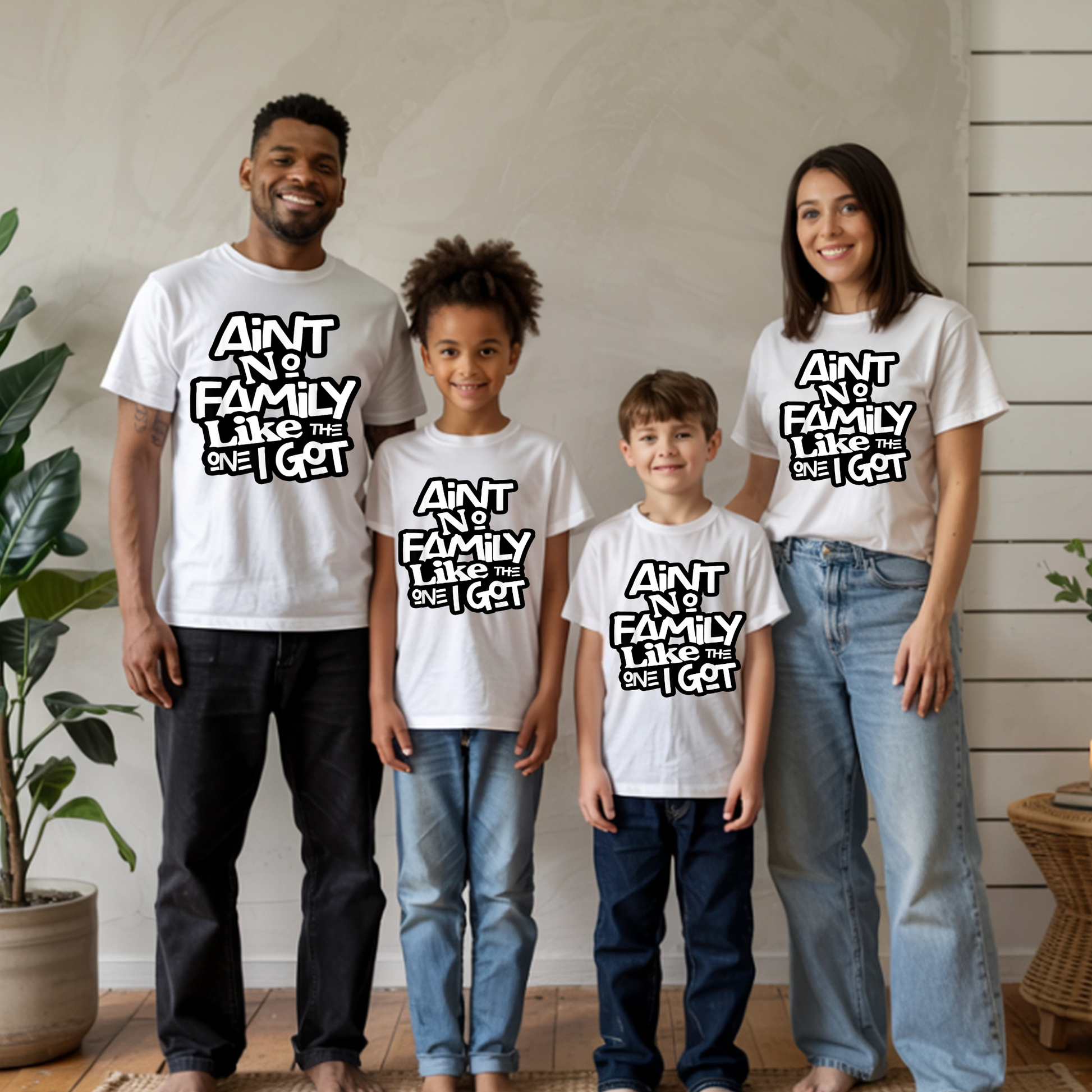 Family of four wearing matching white t-shirts with text, standing indoors.