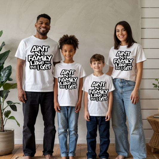 Family of four wearing matching white t-shirts with text, standing indoors.