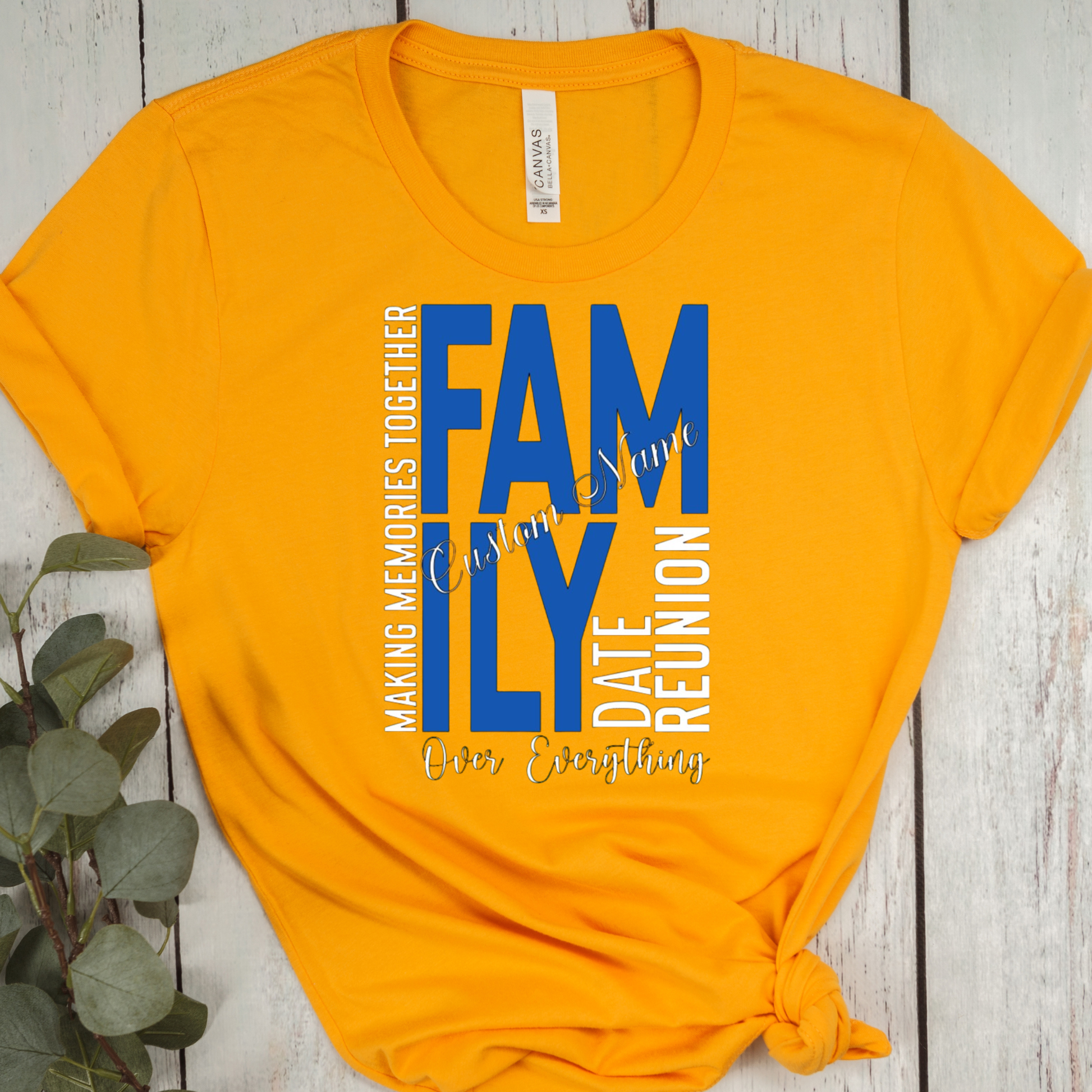Yellow t-shirt with blue and white text on a wooden surface