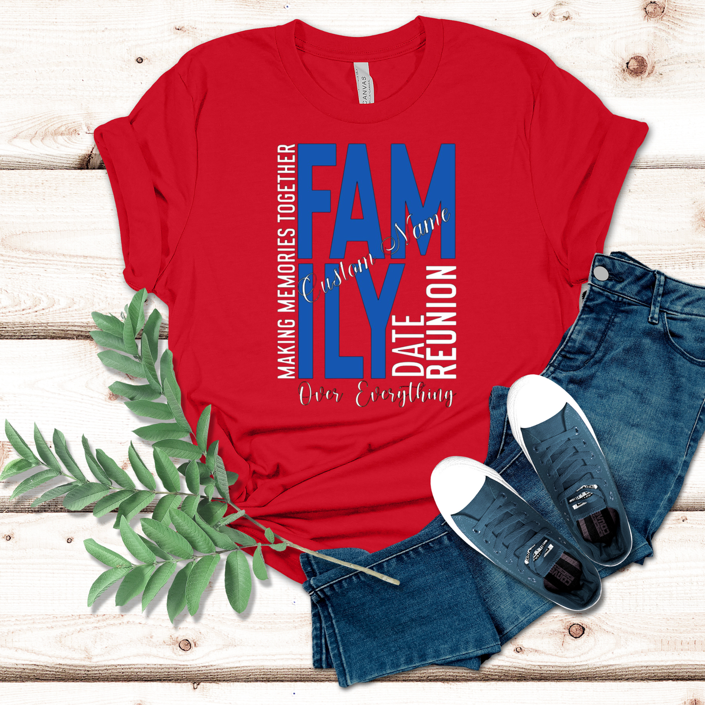 Red t-shirt with family reunion text, jeans, and sneakers on a wooden surface