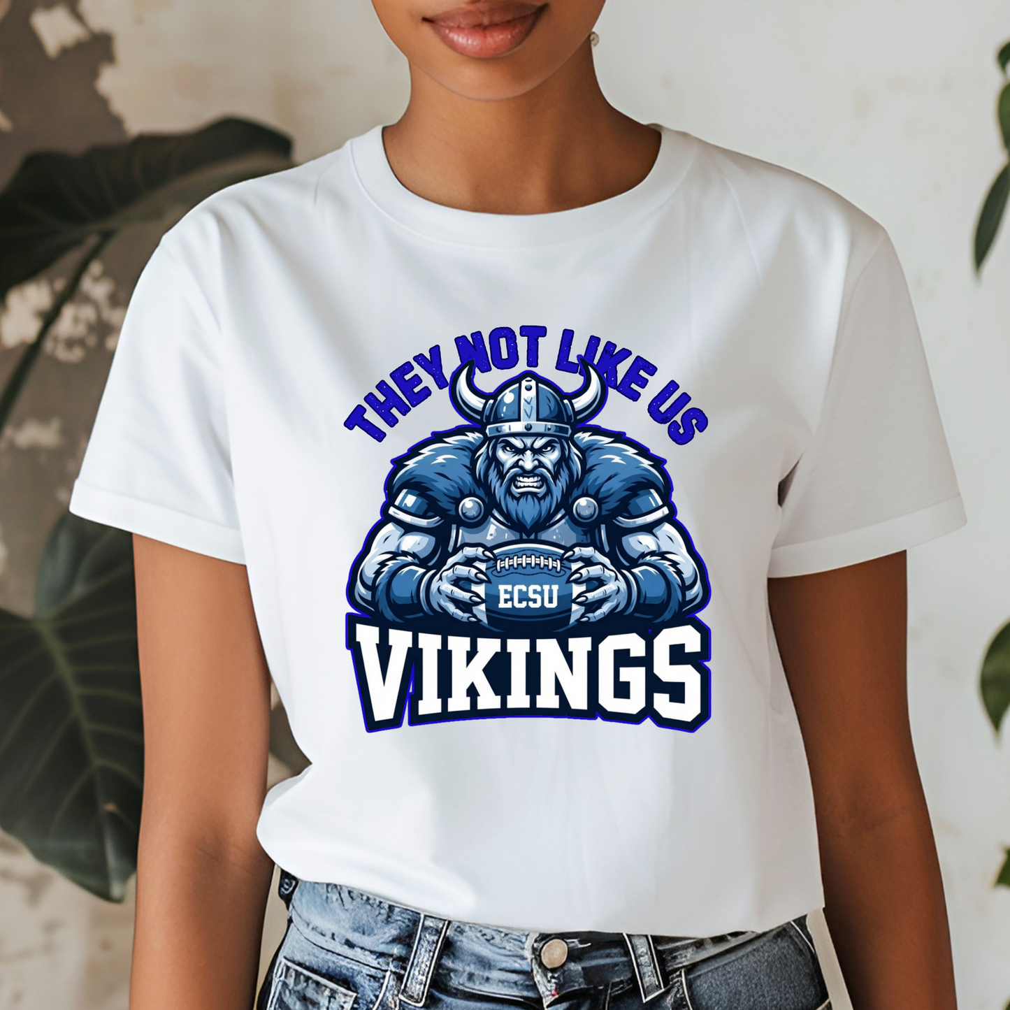 A woman wearing a white graphic t-shirt with a purple and gold print that reads 'PRAIRE VIEW A&M PANTHERS I LOVE MY HBCU' with an illustration of a running panther football player.