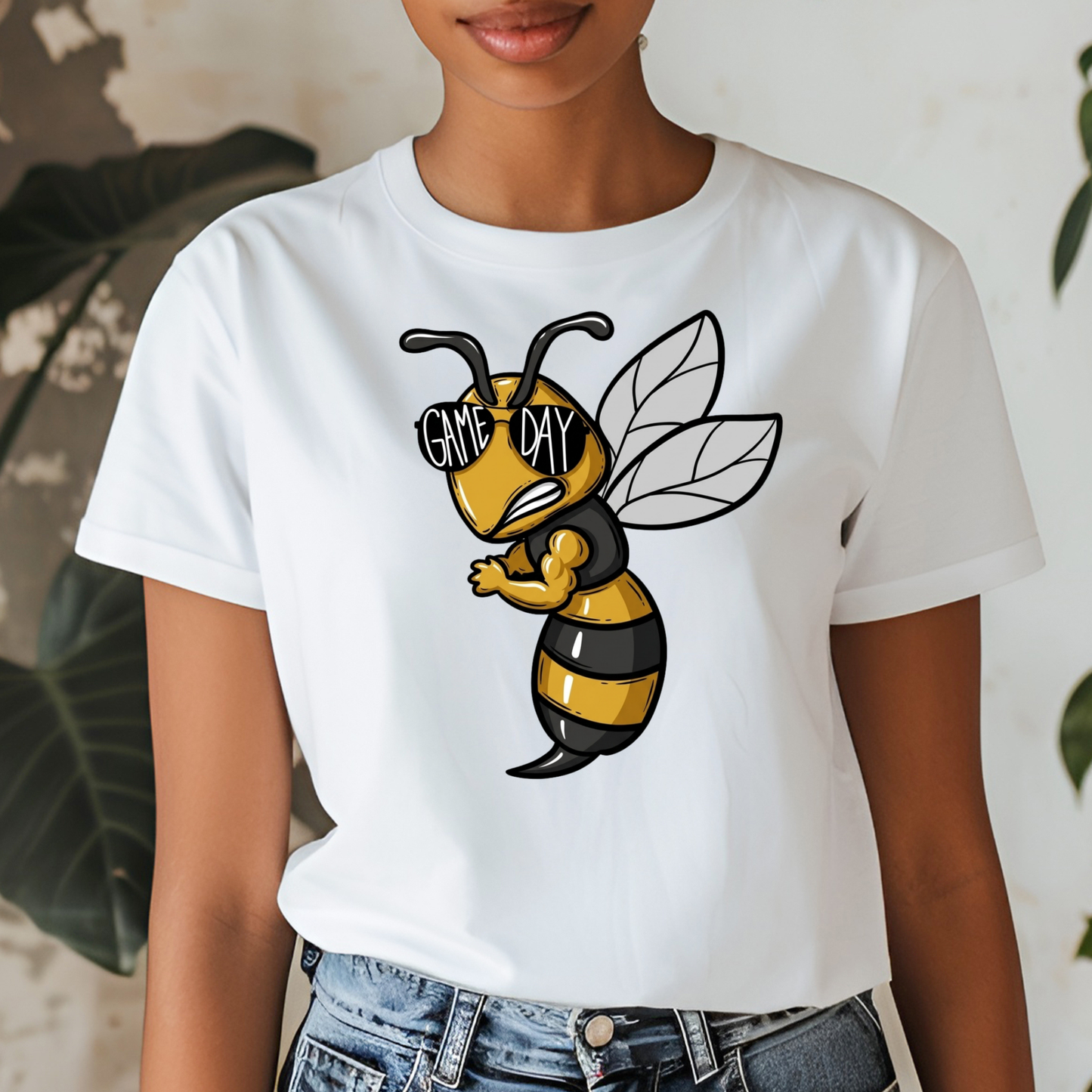 A woman wearing a white short-sleeve graphic t-shirt featuring a cartoon bee wearing black and yellow stripes and sunglasses with the text 'GIVE ME DAY'.