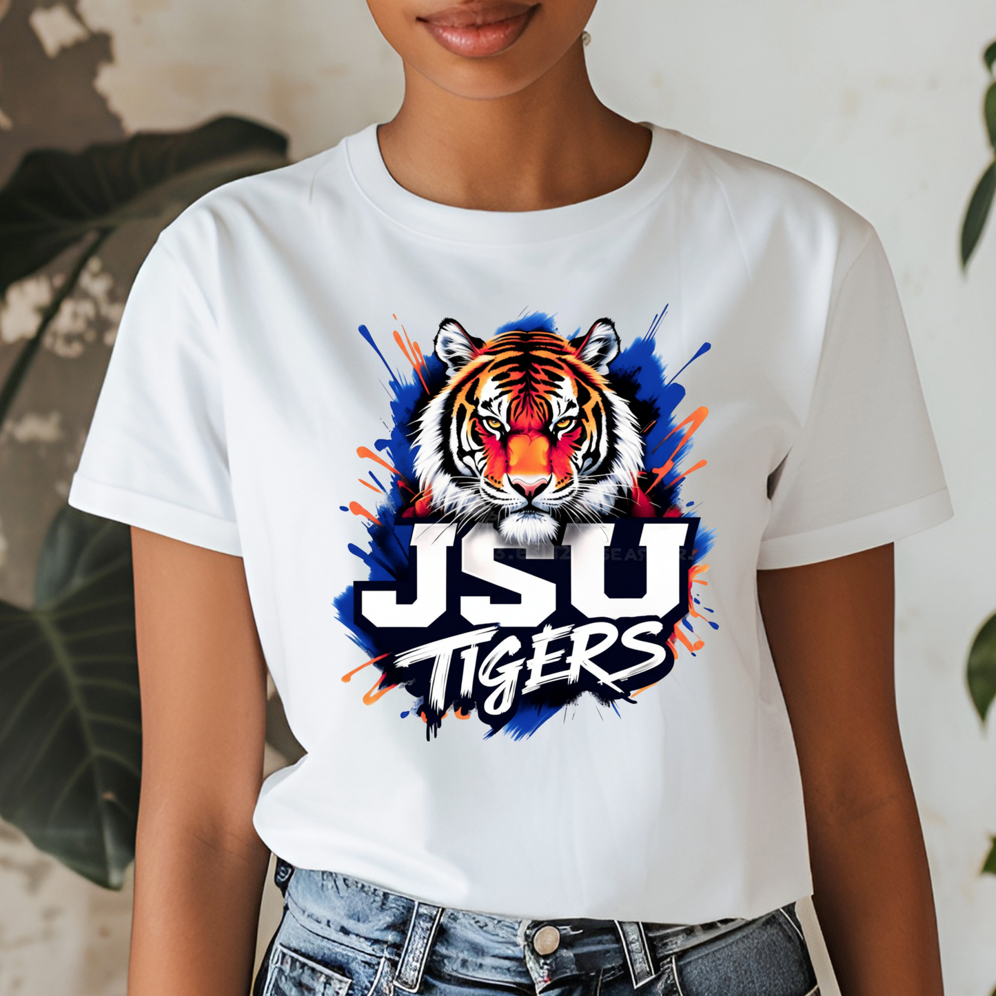 A woman wearing a white graphic t-shirt with a purple and gold print that reads 'PRAIRE VIEW A&M PANTHERS I LOVE MY HBCU' with an illustration of a running panther football player.
