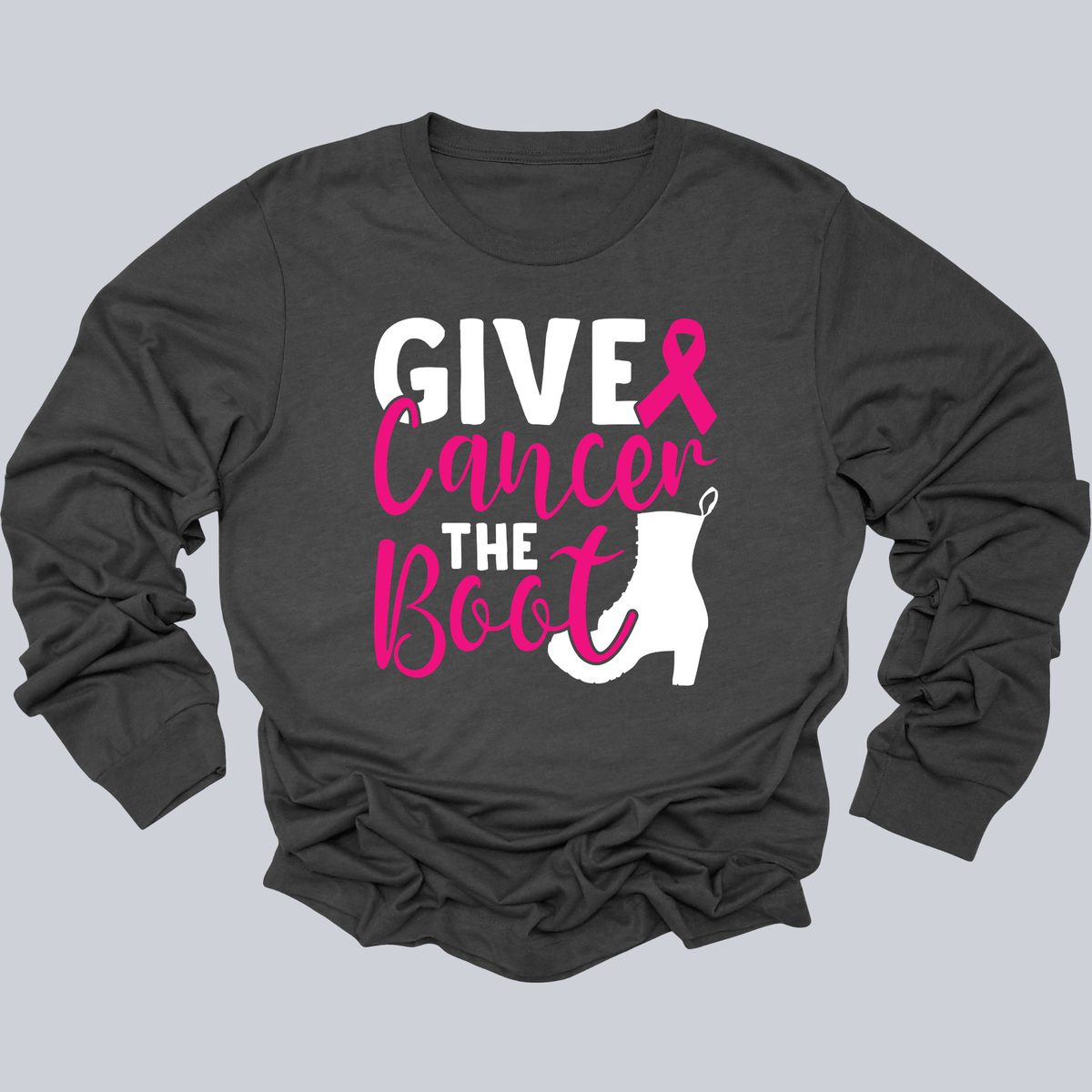 A dark gray long-sleeve t-shirt with a graphic print on the front that reads 'GIVE Cancer THE Boot' in white and pink lettering, accompanied by a pink ribbon and a white boot silhouette, displayed on a solid gray background.