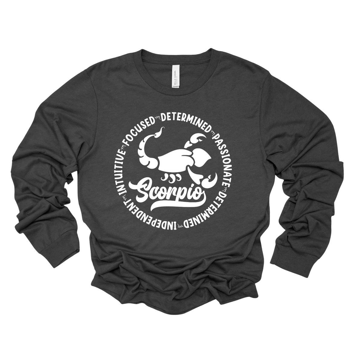 Woman wearing a black crewneck sweatshirt featuring a white circular Scorpio zodiac graphic with a scorpion illustration, the word "Scorpio," and trait keywords like intuitive, focused, determined, passionate, and independent.