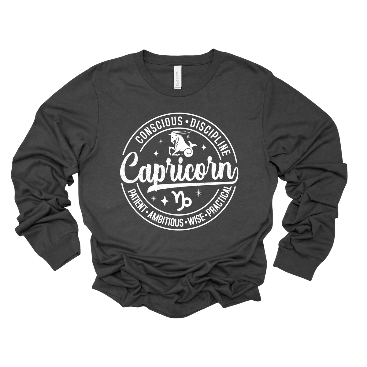 A dark charcoal gray long-sleeve t-shirt with a white graphic print on the front. The graphic features a circular design with the word 'Capricorn' in a script font, flanked by the words 'CONSCIOUS • DISCIPLINE' on top and 'PARENT • AMBITIOUS • WISE-FUNCTIONAL' on the bottom, surrounding a central 'Capricorn' zodiac symbol.