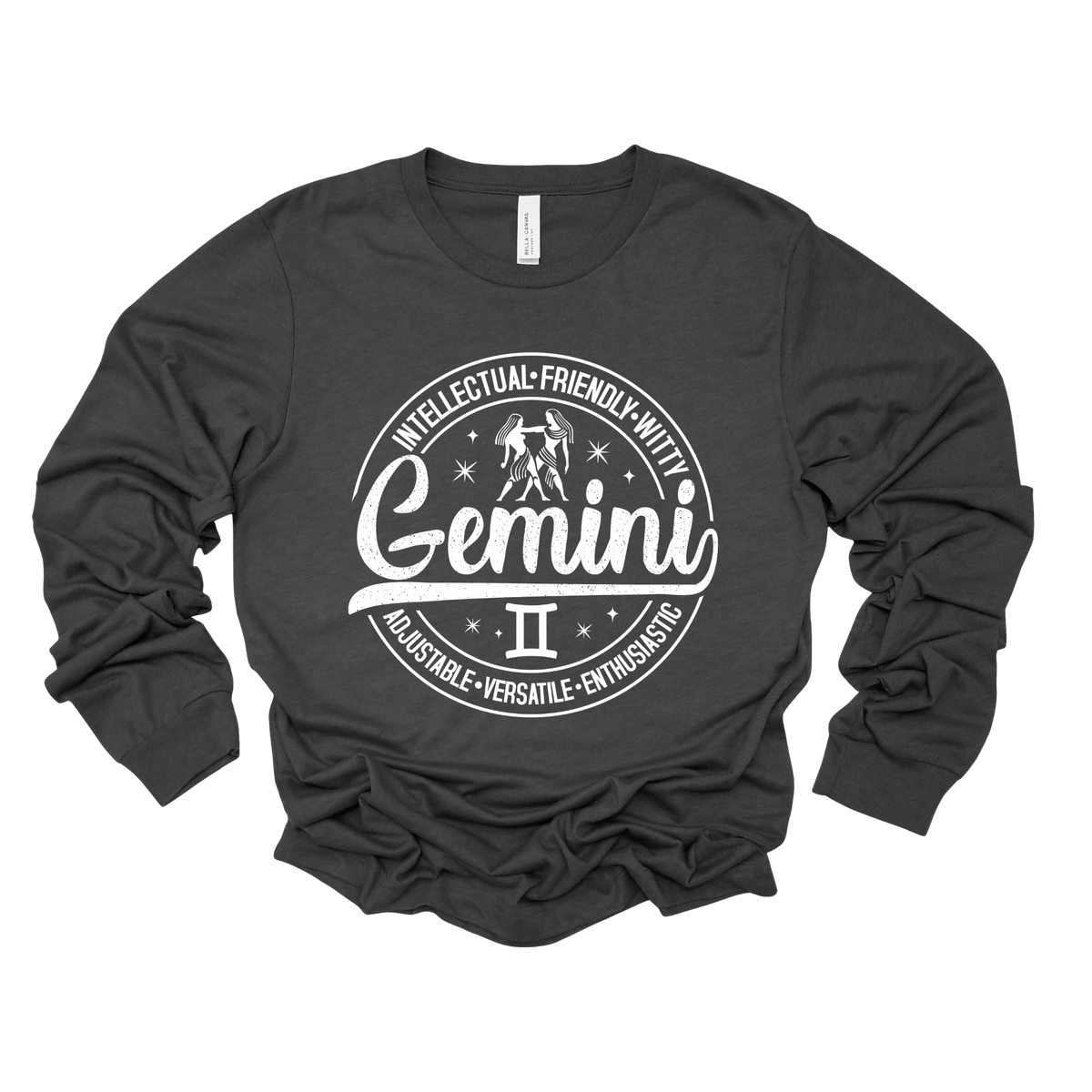 grey t-shirt laid flat, featuring a circular white Gemini zodiac graphic with the twins illustration, the word "Gemini," and trait keywords like intellectual, friendly, witty, enthusiastic, versatile, and adjustable.