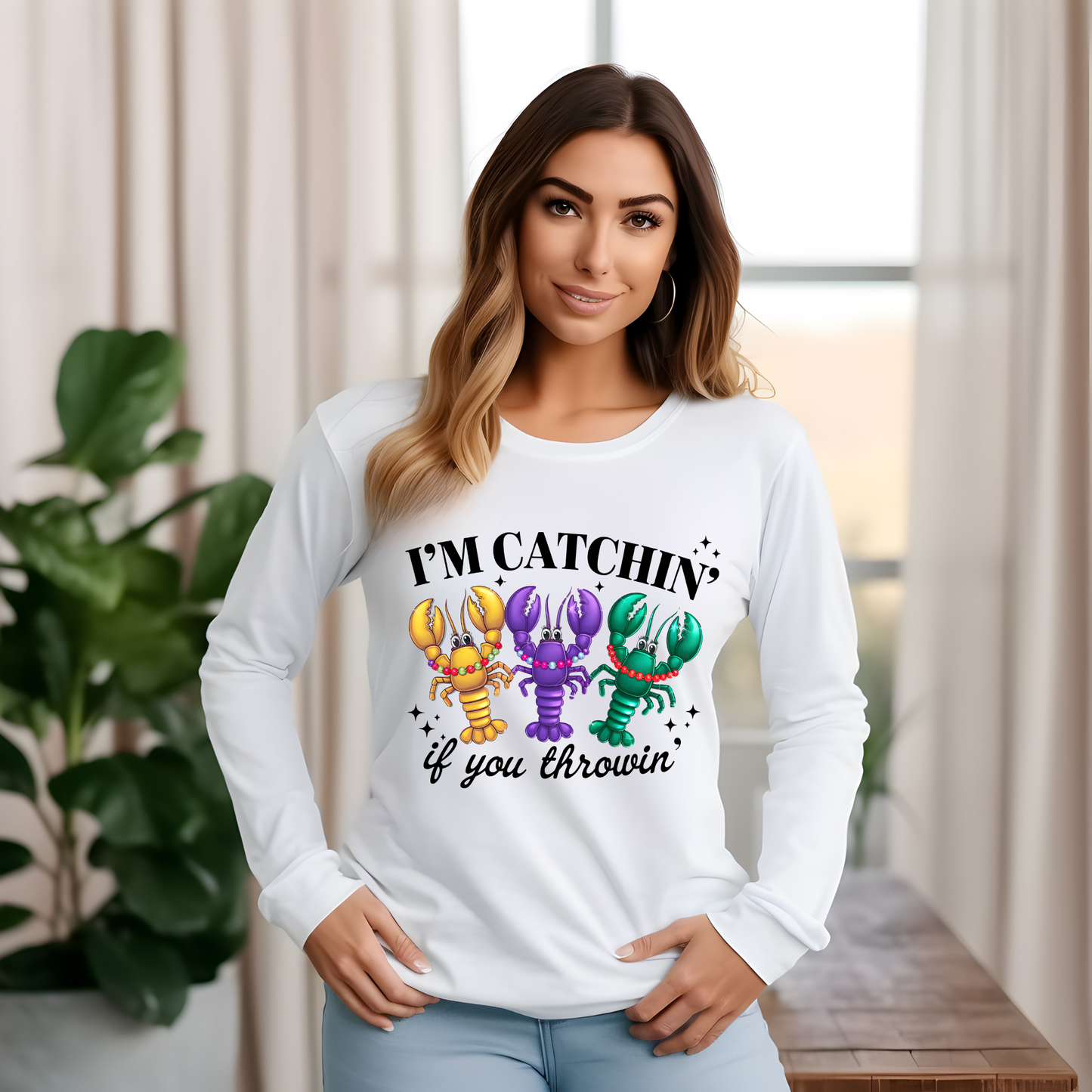 Woman wearing a white long-sleeve shirt with colorful lobster graphics and text.
