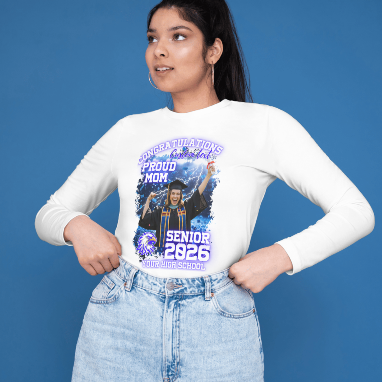 Person wearing a white long-sleeve shirt with a graduation-themed design on a blue background Customizable graduation photo t-shirt featuring senior portrait, school mascot, and sports organization logos in school colors
