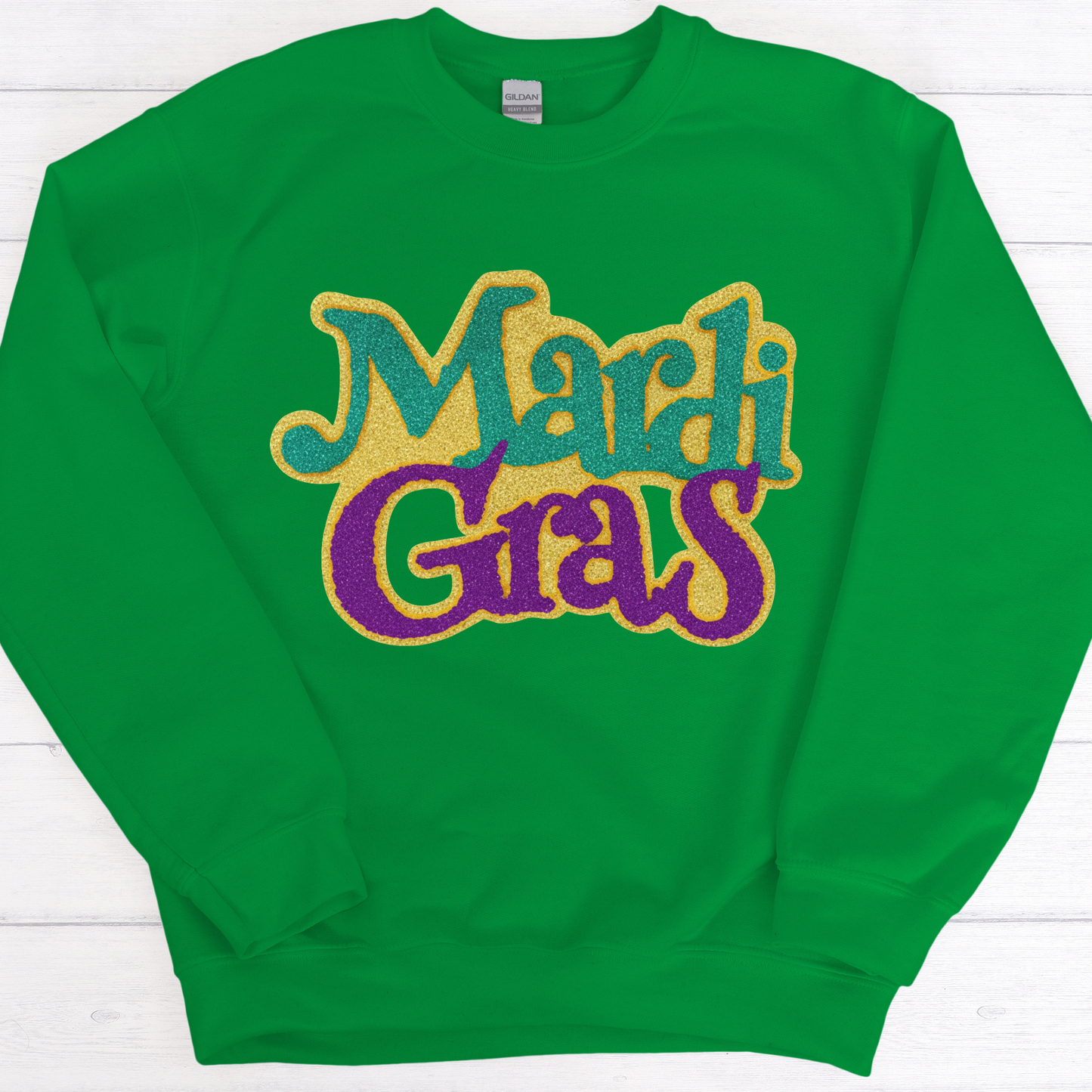 Green sweatshirt with 'Mardi Gras' text in colorful letters on a white background