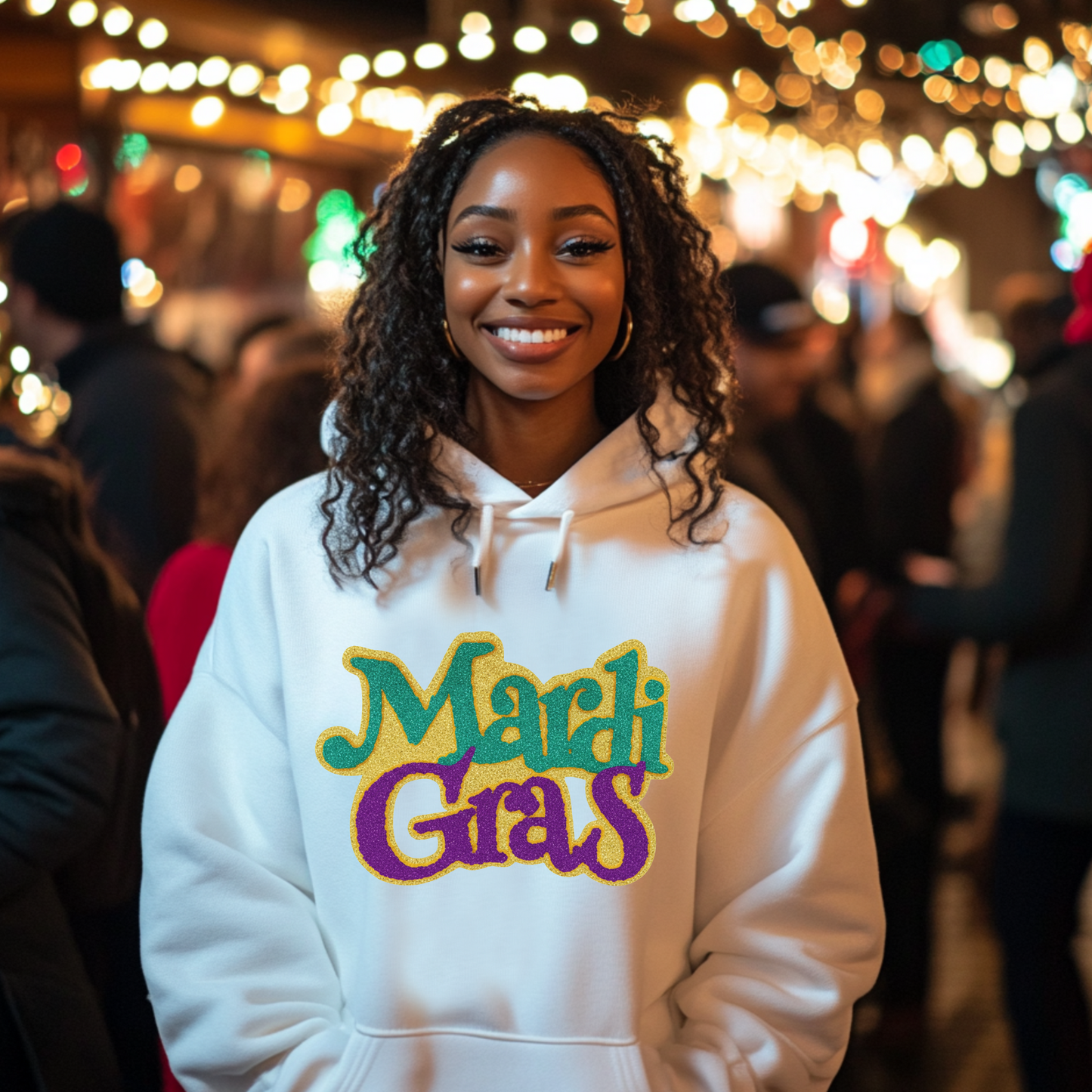 Person wearing a hoodie with 'Mardi Gras' text in a festive setting