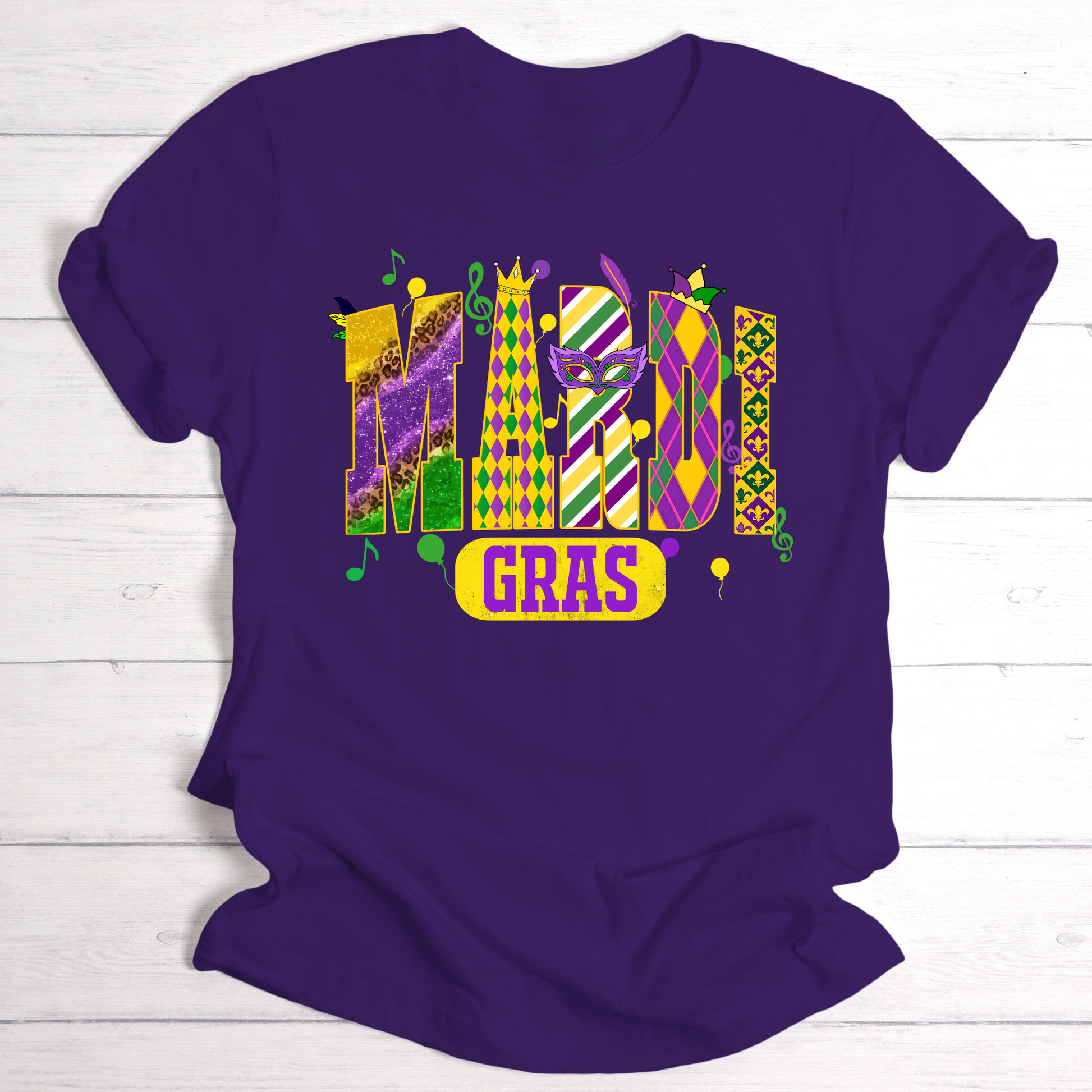 Purple t-shirt with Mardi Gras-themed design on a wooden surface