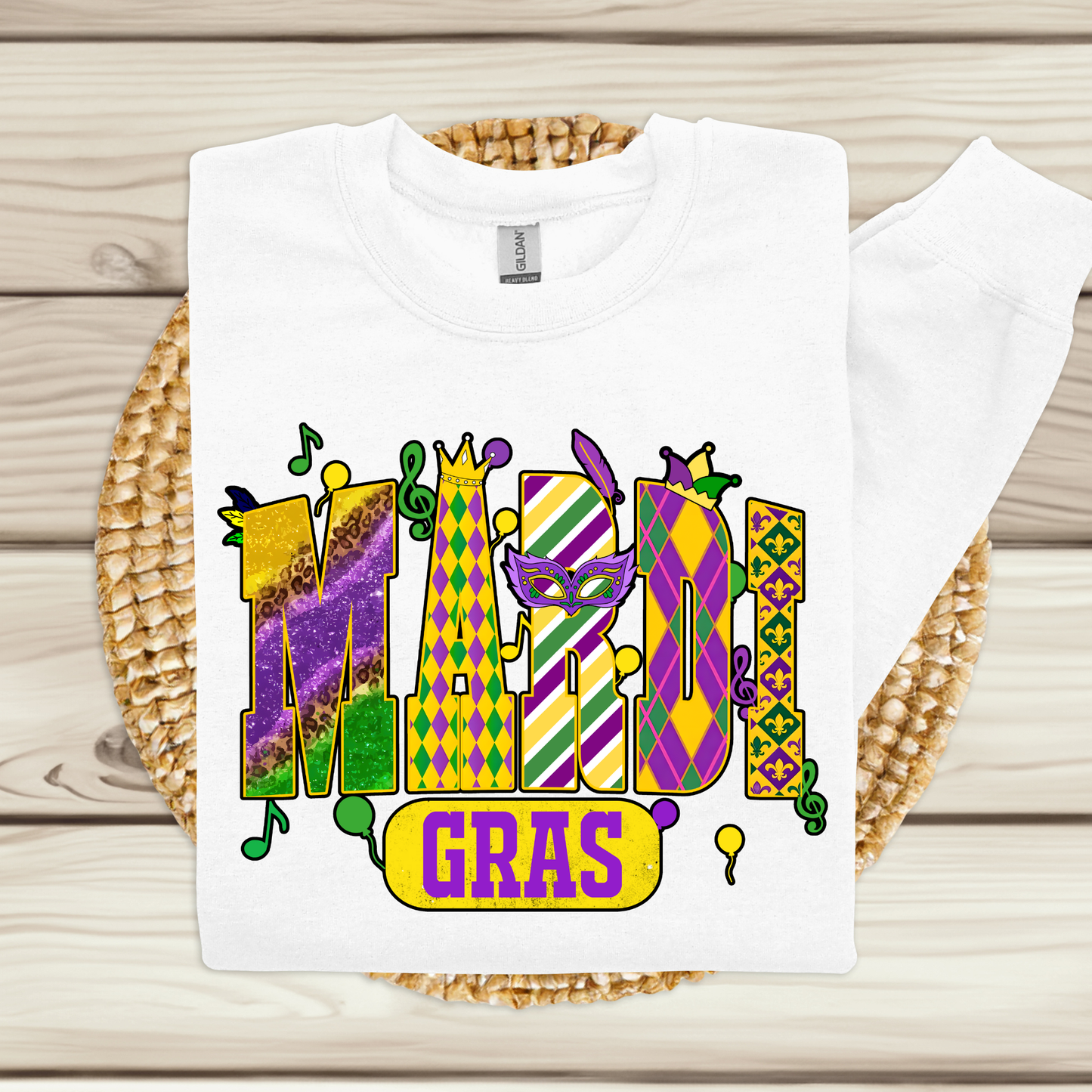 White t-shirt with Mardi Gras-themed design on a woven mat