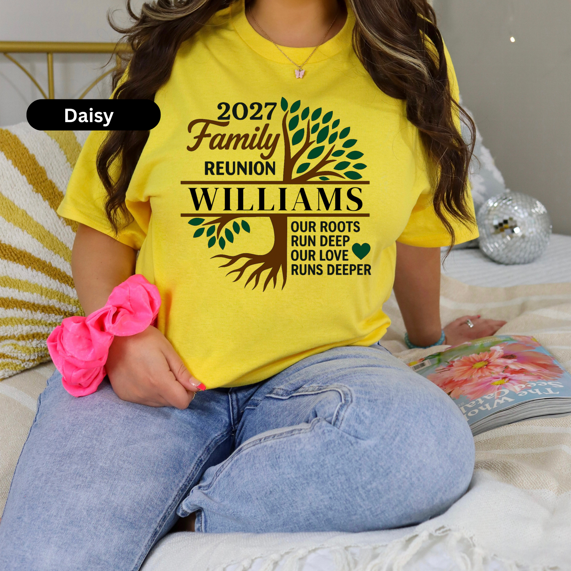Person wearing a yellow t-shirt with family reunion design, sitting on a couch.