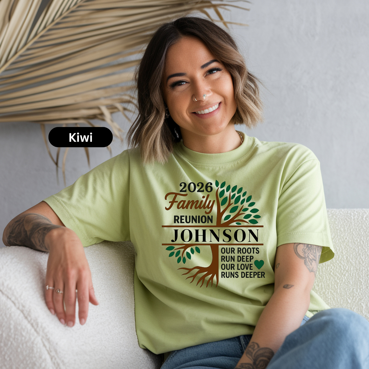 Woman wearing a light green t-shirt with '2026 Family Reunion Johnson' design, sitting on a white couch.