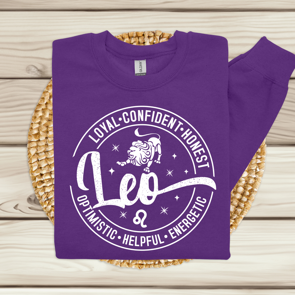 Woman wearing a vibrant purple Leo zodiac t-shirt featuring a white round graphic with a lion illustration, the word "Leo," and positive trait keywords like loyal, confident, honest, energetic, helpful, and optimistic.
