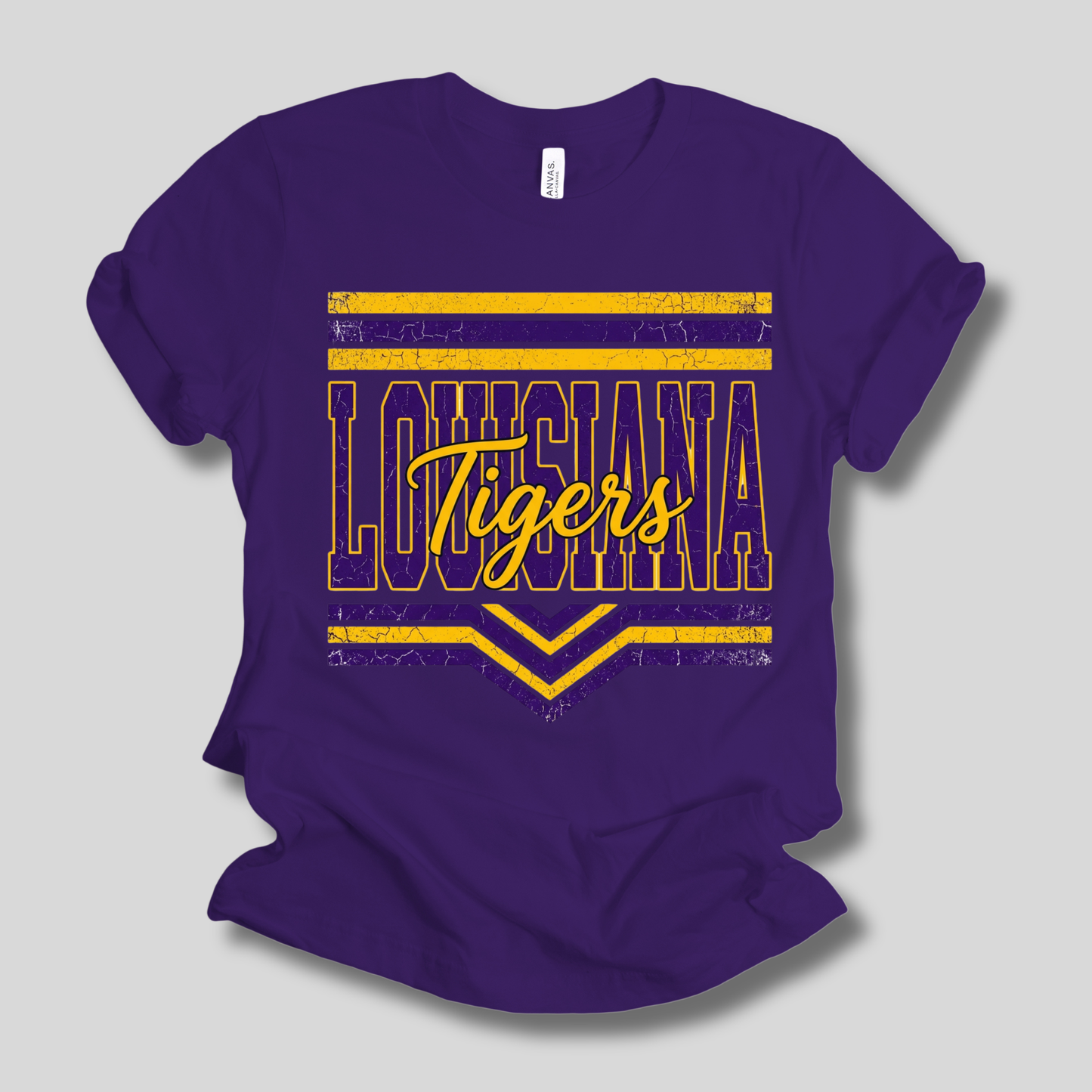 A purple short-sleeve crewneck t-shirt with a distressed yellow graphic on the front reading 'LOUISIANA Tigers' with horizontal stripes and chevron accents, shown on a light gray background.