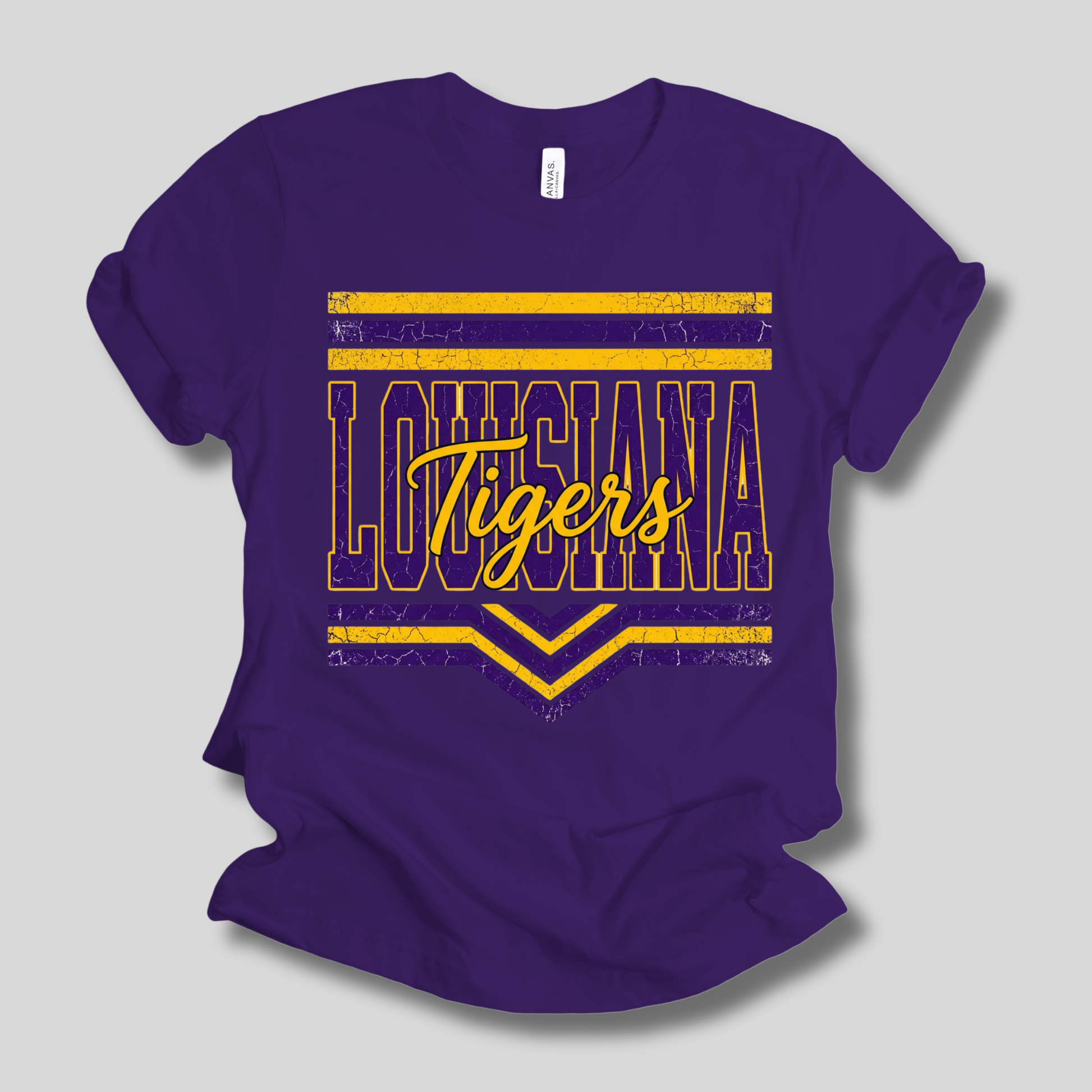 A purple short-sleeve crewneck t-shirt with a distressed yellow graphic on the front reading 'LOUISIANA Tigers' with horizontal stripes and chevron accents, shown on a light gray background.