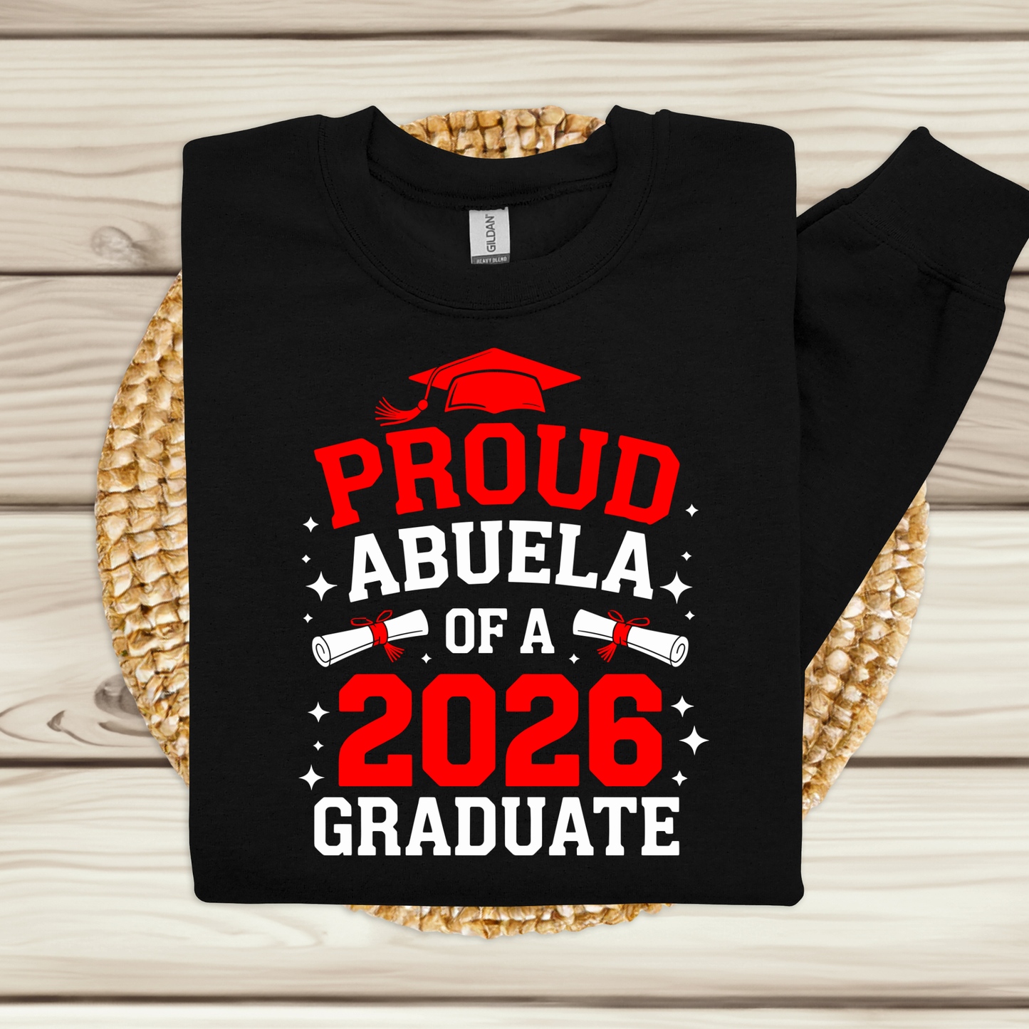 Black sweatshirt with 'Proud Abuela of a 2026 Graduate' text on a woven mat.