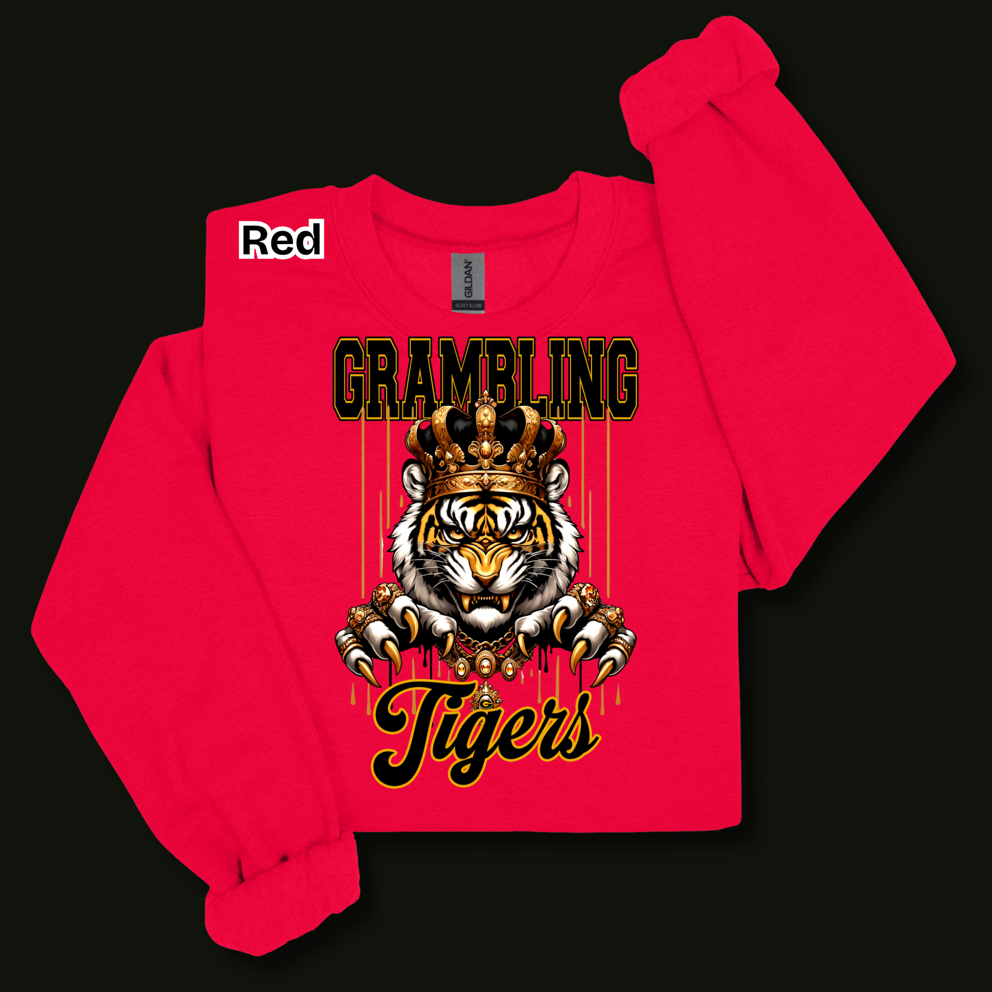 A bright red long-sleeve sweatshirt laid flat on a black background, featuring a large graphic of a tiger wearing a gold crown with the words 'GRAMBLING Tigers' in black and gold lettering. A small label near the collar reads 'Red'.