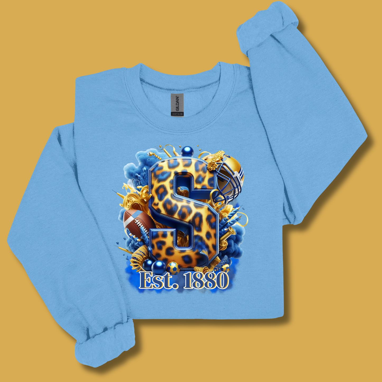 A light blue long-sleeve crop sweatshirt with a large graphic print on the front. The graphic features a leopard-print 'S' with a football helmet, football, and blue smoke effects, with 'Est.