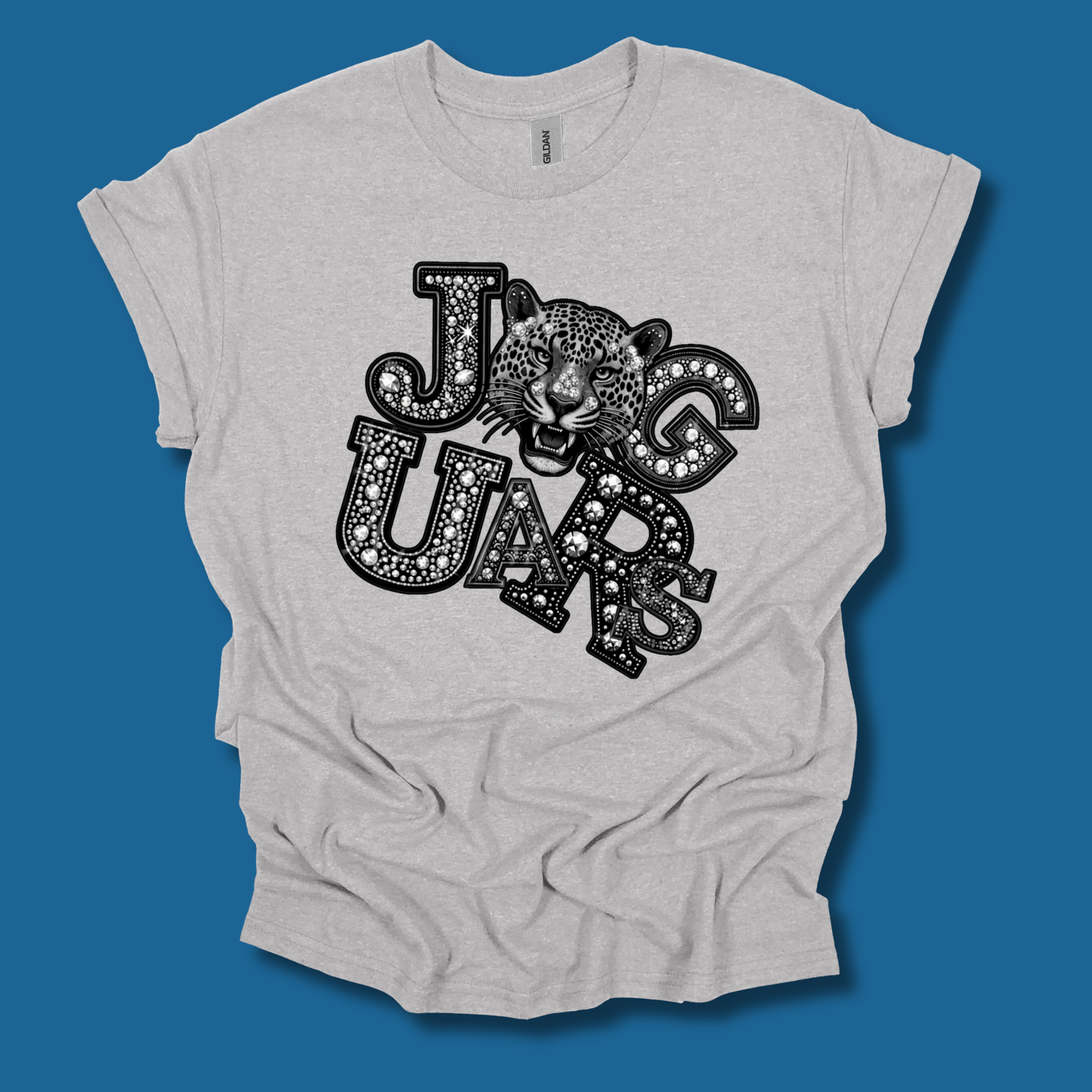 A light heather gray t-shirt with a black graphic print reading 'BULL DOG' in decorative block letters, styled with a bulldog face inside the 'O' in 'DOG'. The t-shirt is displayed flat against a solid dark blue background.