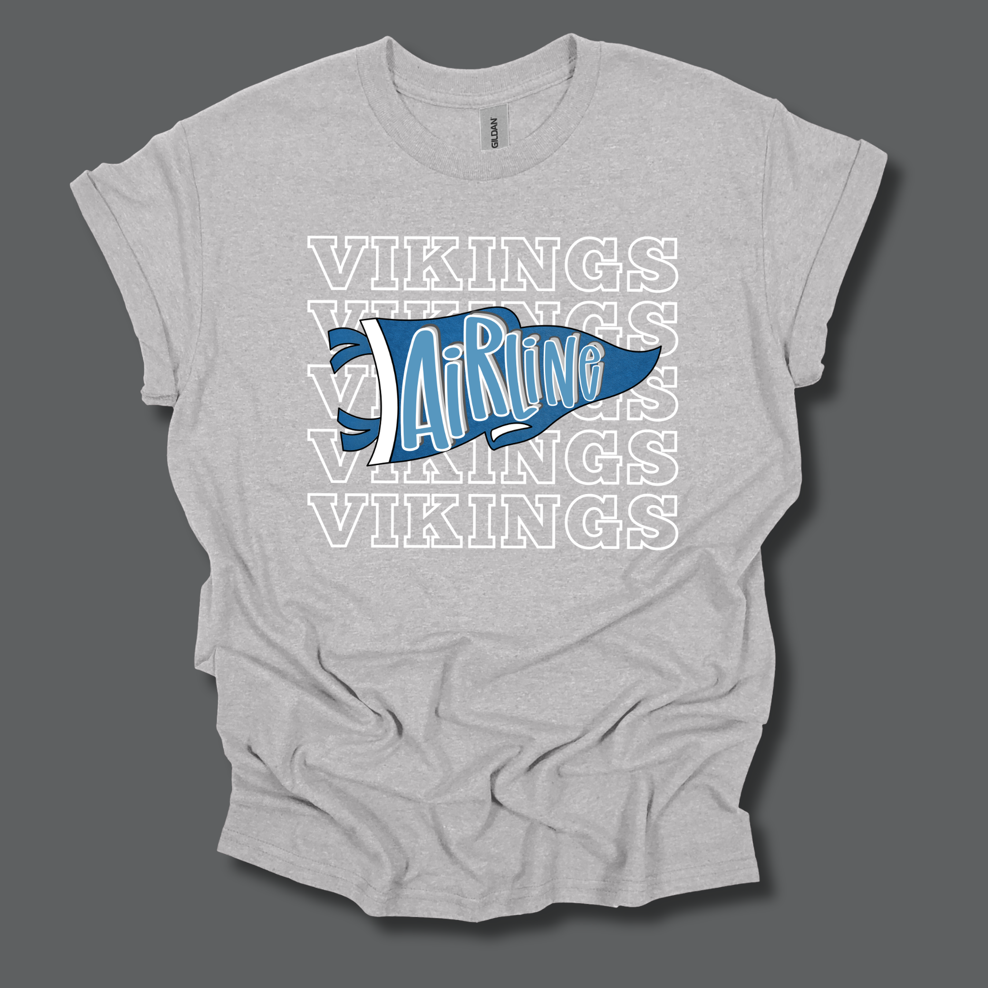 A light heather gray t-shirt with a graphic design featuring the word 'VIKINGS' repeated in white outline text and a blue pennant shape in the center with 'AirRug' written in white script.