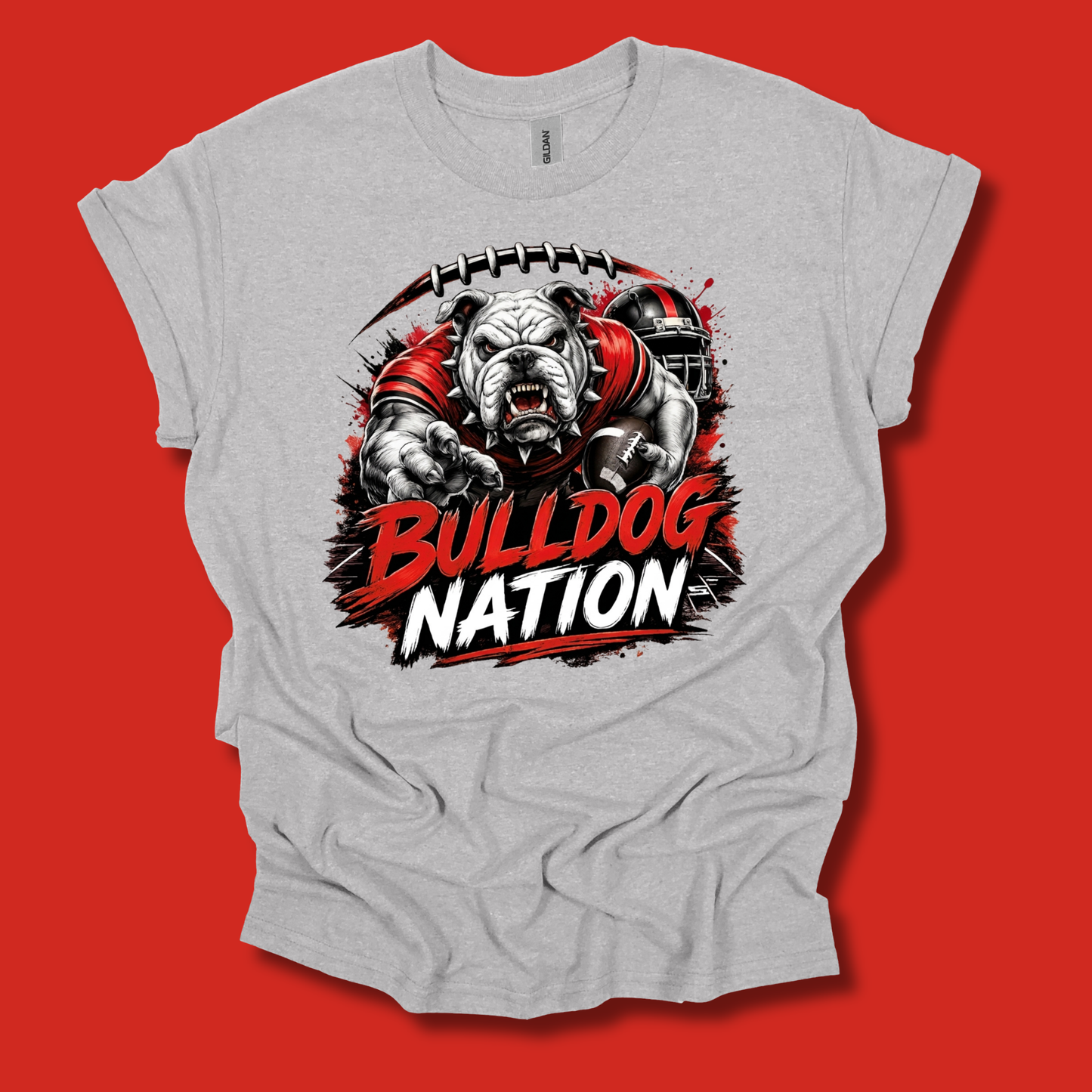 A light heather gray t-shirt with a graphic print of a bulldog football player and the text 'BULLDOG NATION' in red and white, displayed against a solid red background.