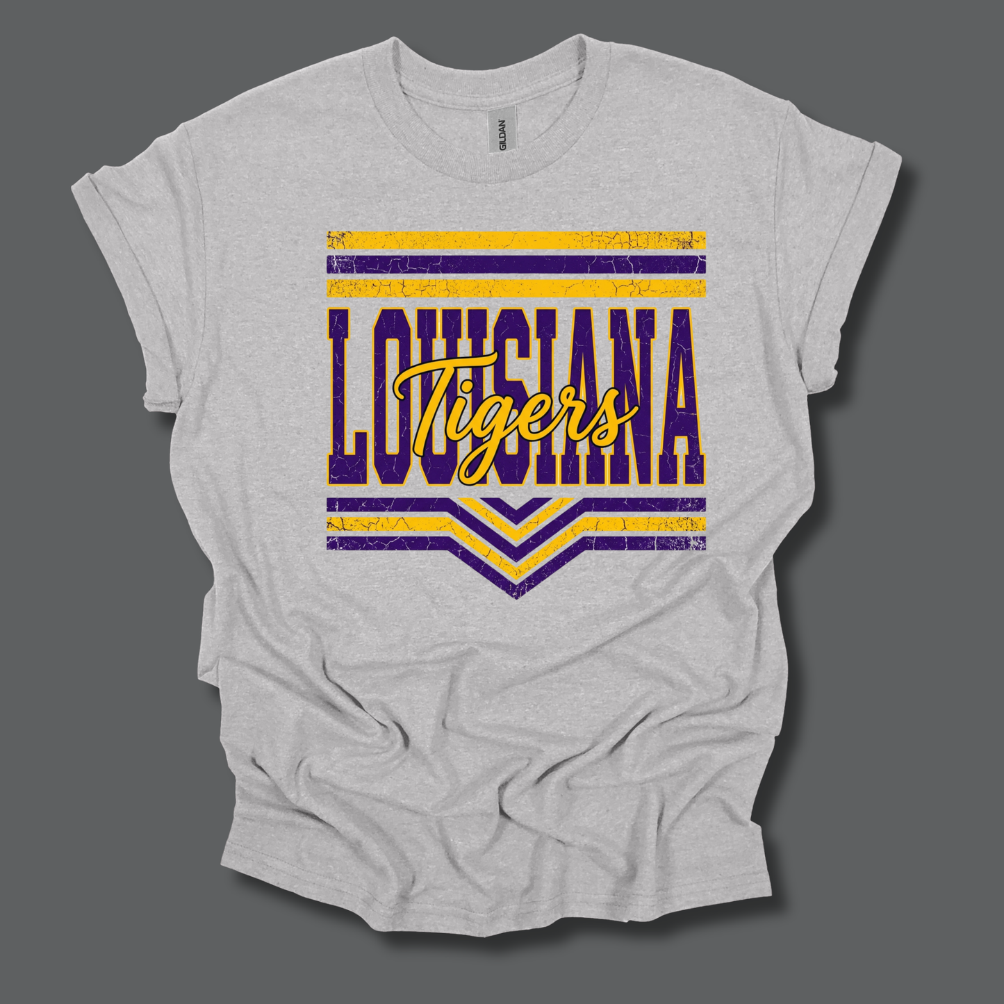 A light heather gray t-shirt with a distressed graphic on the front featuring the word 'LOUISIANA' in purple and yellow block letters with 'Tigers' in yellow script across the middle, set against a dark gray background.
