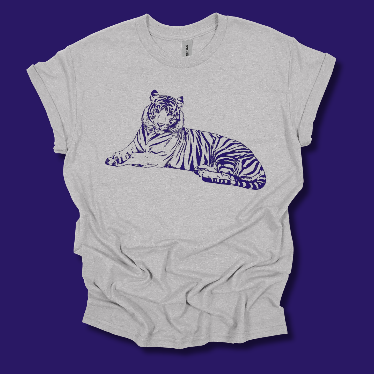 A light heather gray t-shirt with a dark blue line art graphic of a resting tiger on the chest, displayed flat against a solid dark purple background.