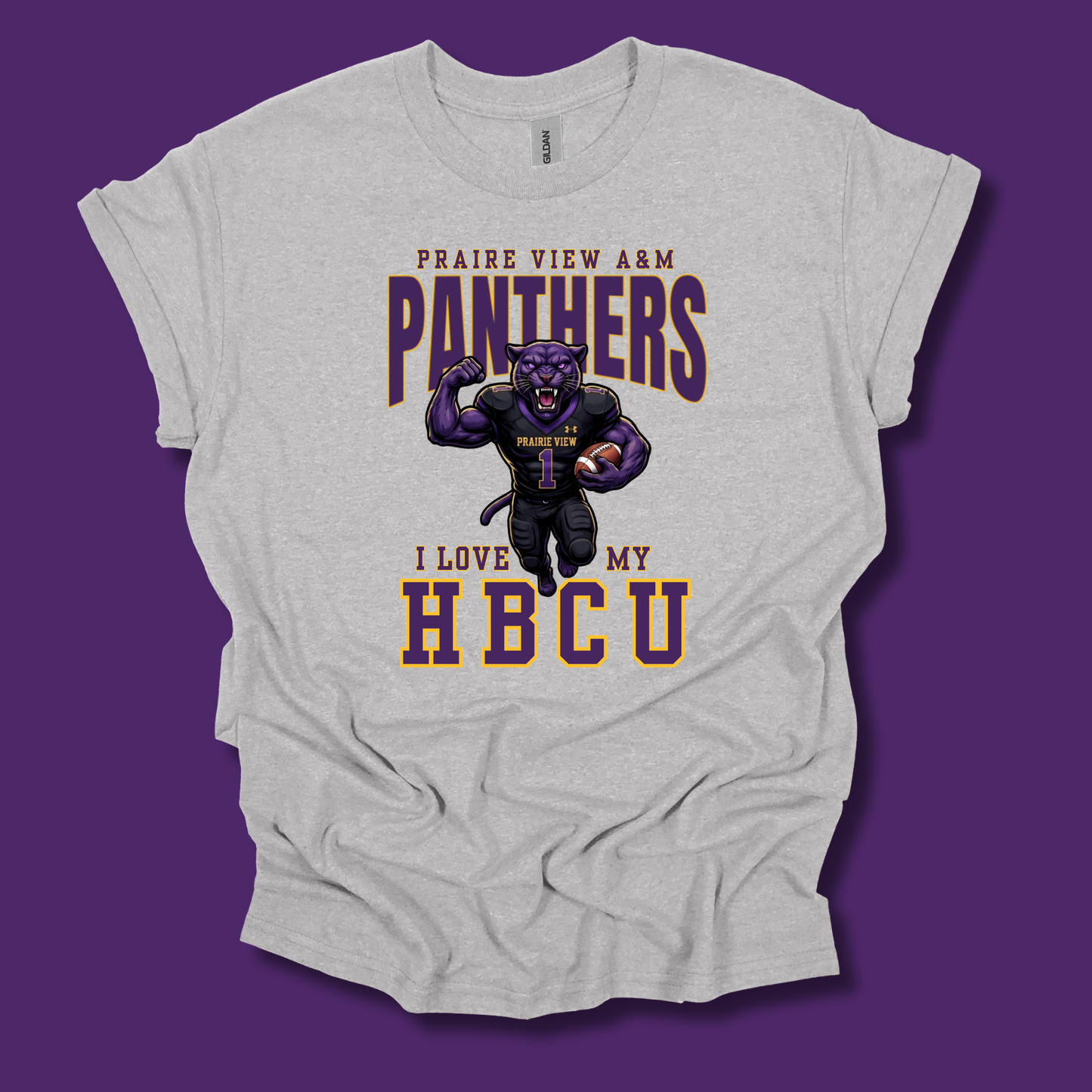 A light heather gray graphic t-shirt featuring a purple and gold design with the text 'PRAIRIE VIEW A&M PANTHERS I LOVE MY HBCU' and a cartoon panther mascot, shown against a solid purple background.