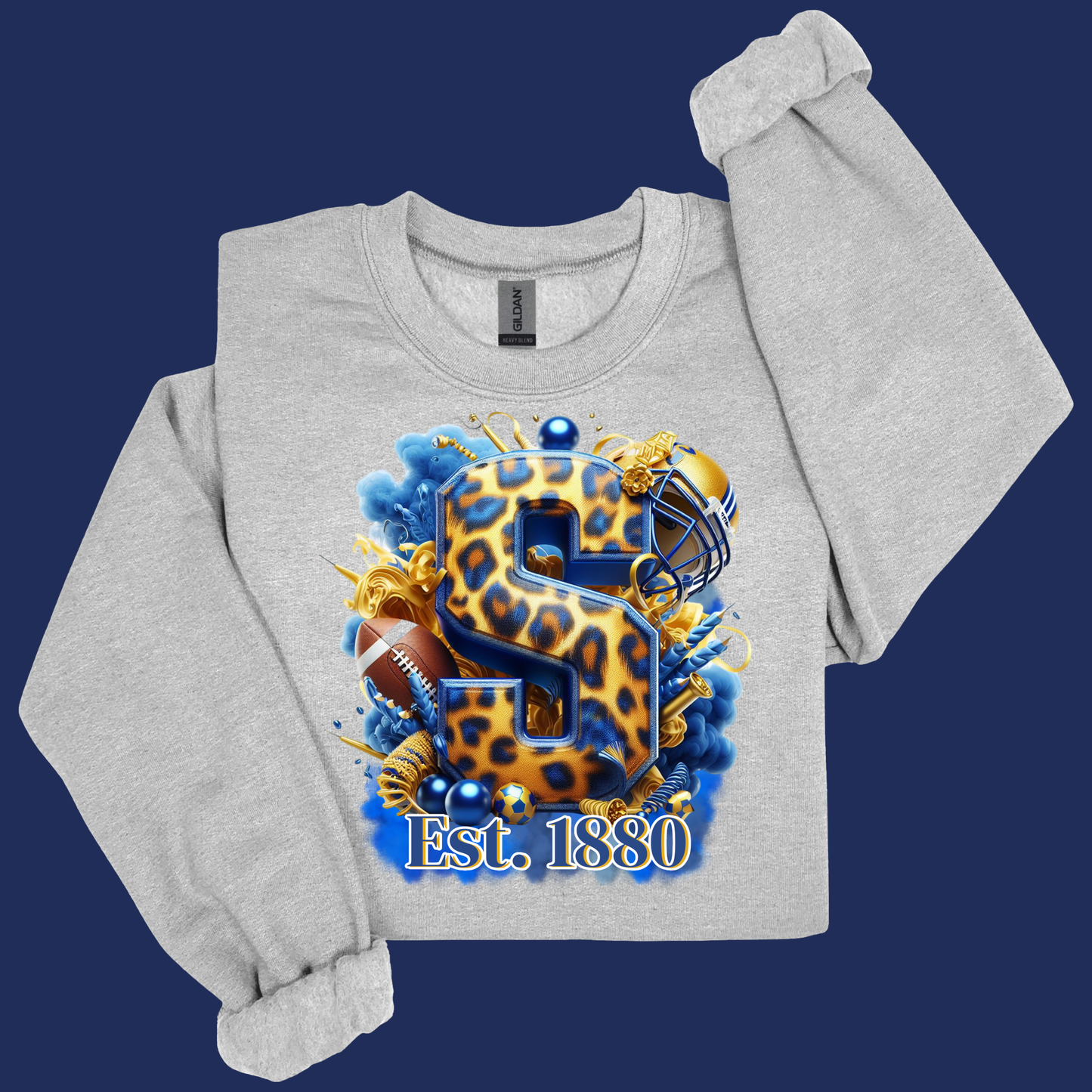 A light heather gray sweatshirt with a long sleeve rolled up, featuring a large graphic print of a leopard-print letter 'S' with football and sports elements, and the text 'Est. 1830' on a dark blue background.